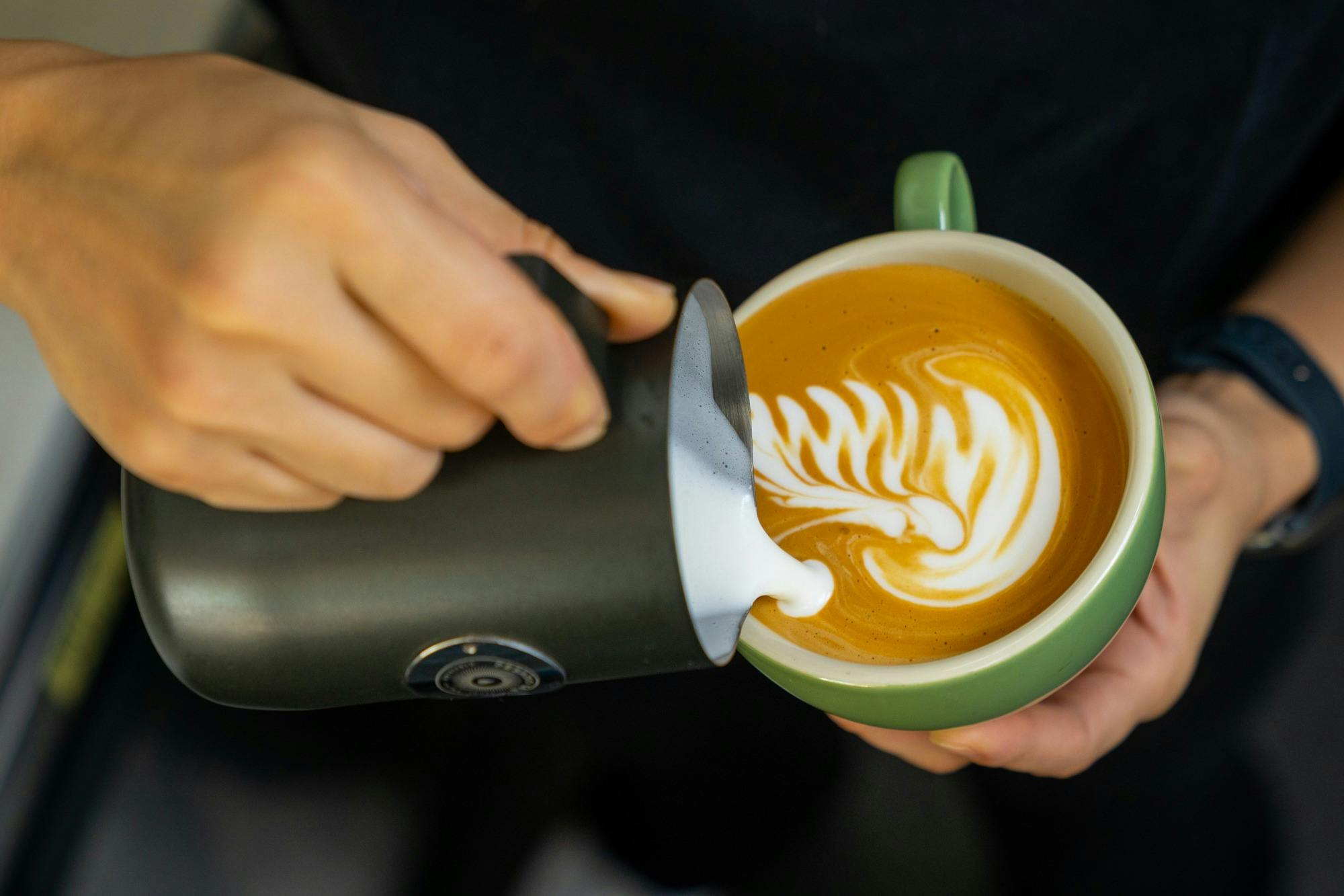 Pouring milk into coffee cup
