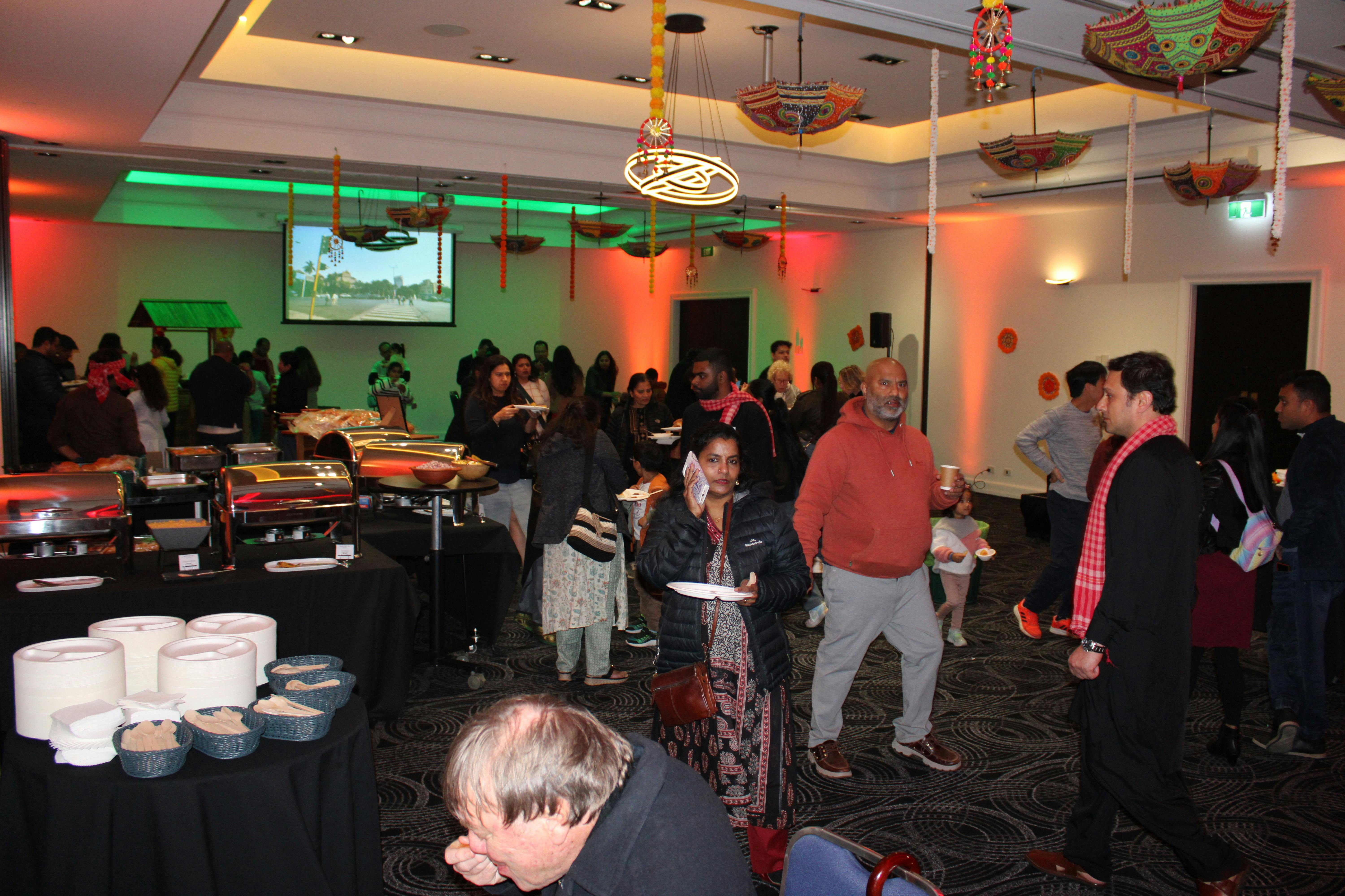 Busy event space filled with people having fun, live music & good food