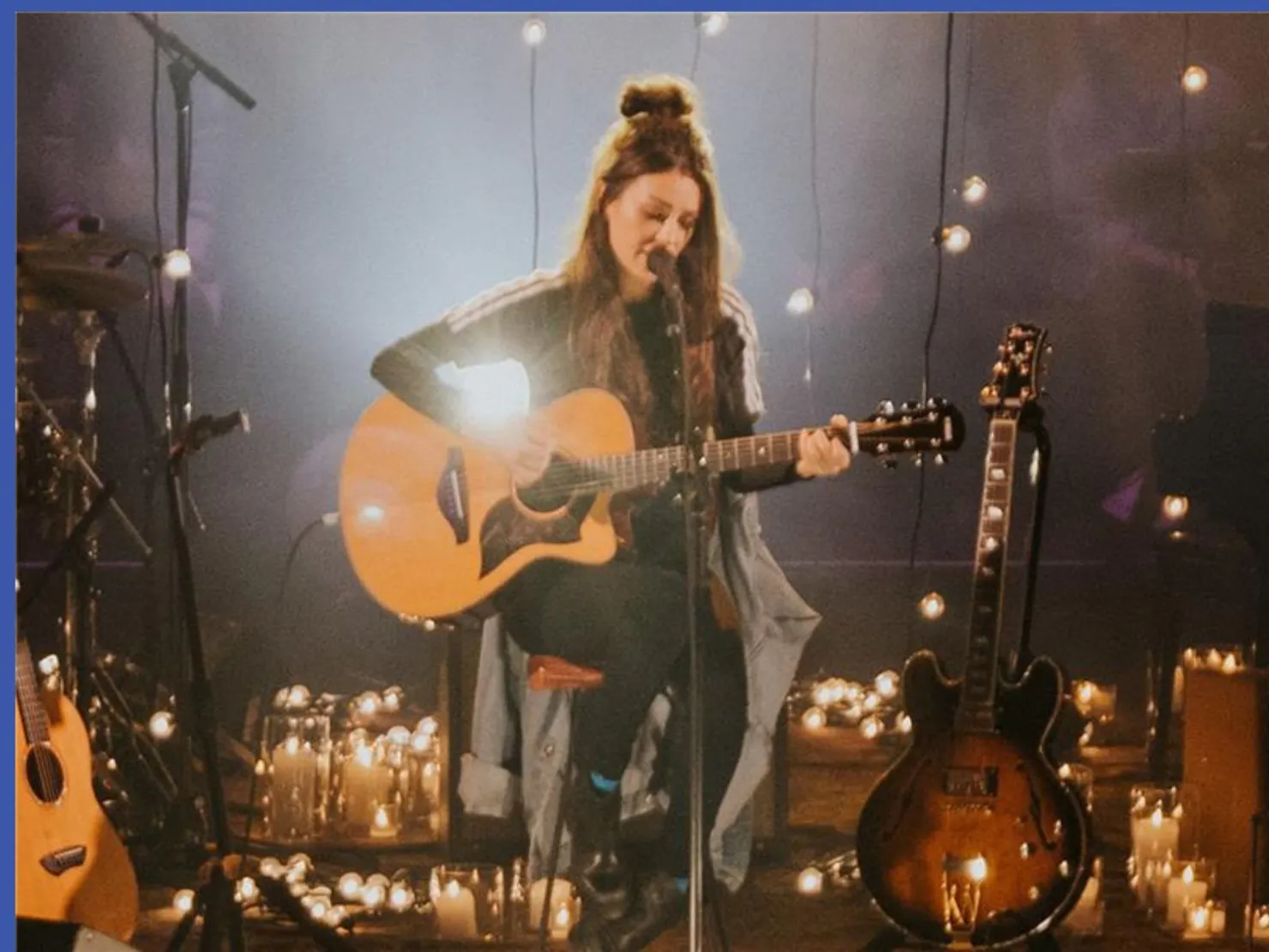 Amy sitting on a stool with a guitar