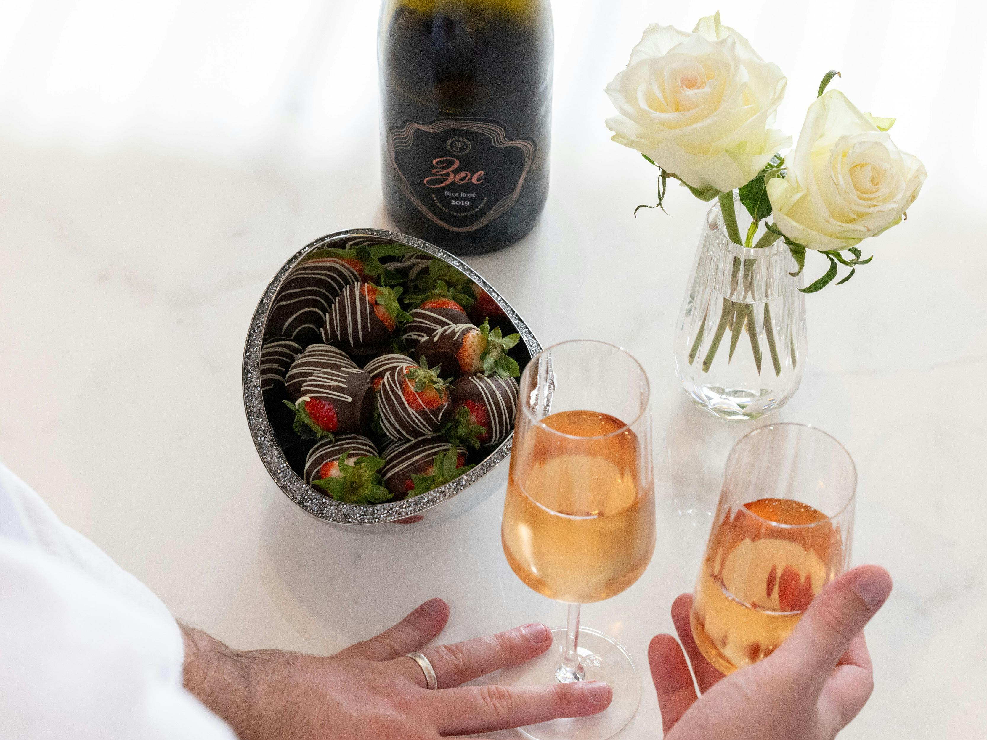 Two glasses of champagne and chocolate covered strawberries