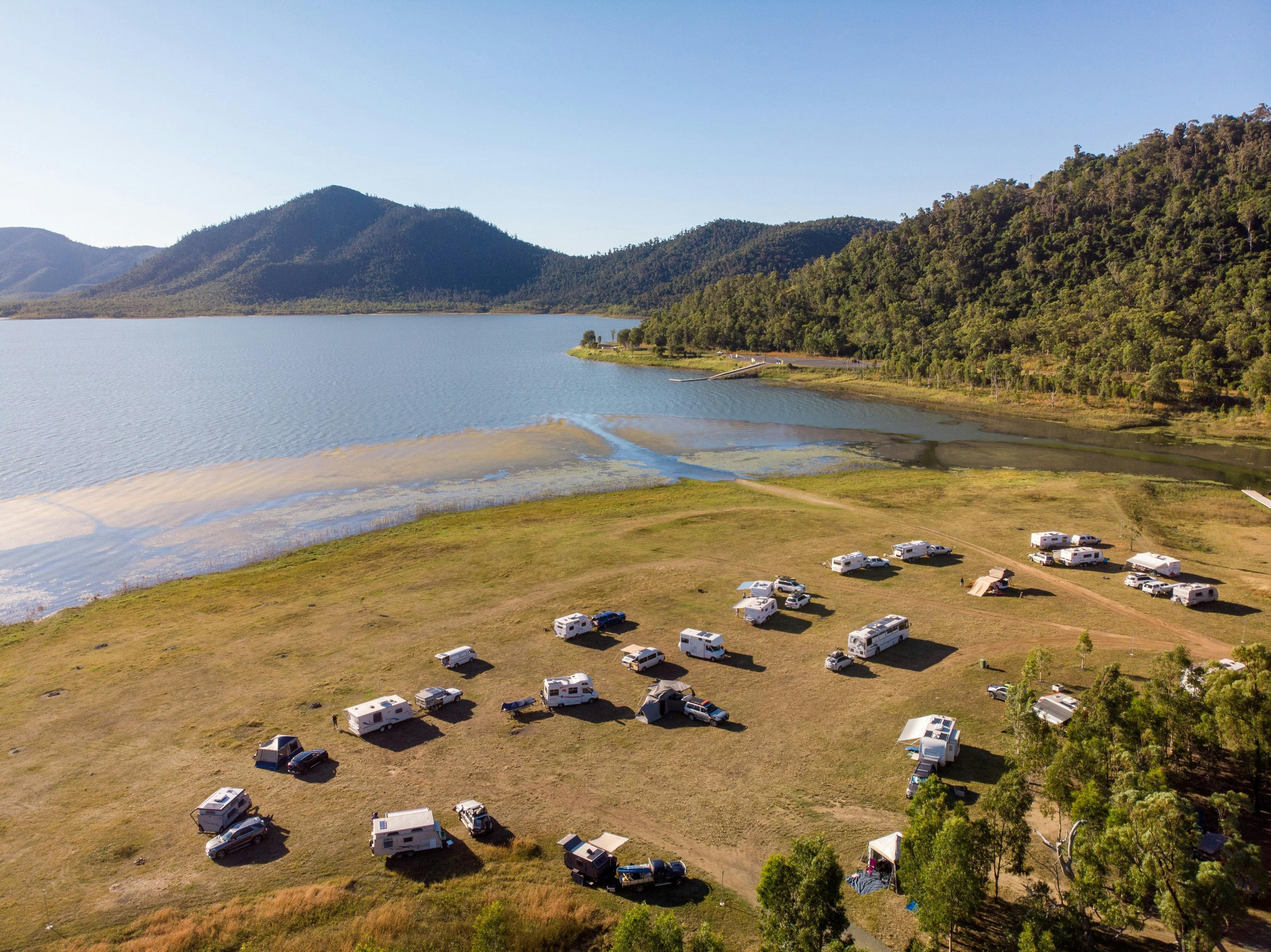 Caravans and campers at the Lake Proserpine with rolling hills in the background