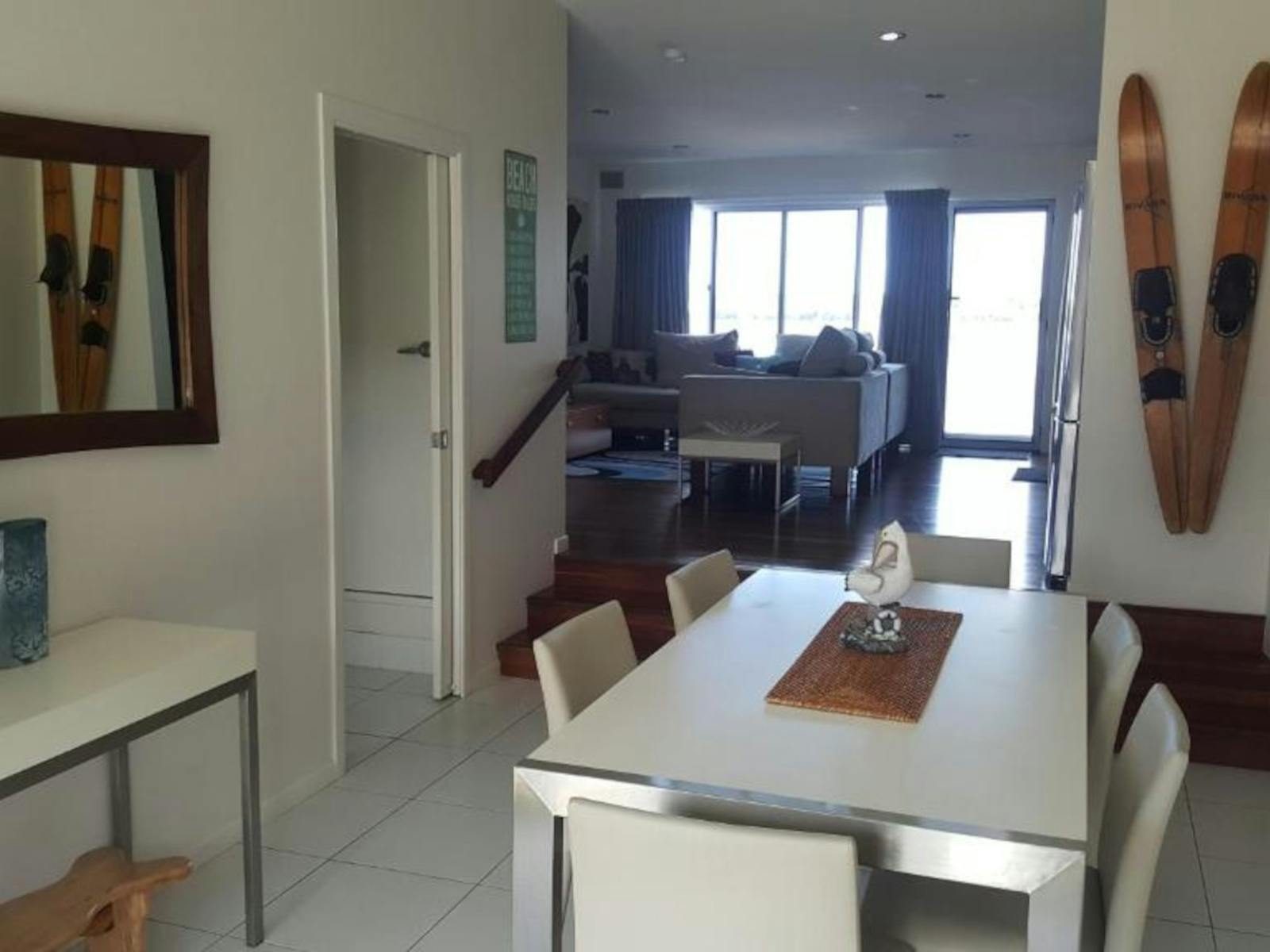 interior photo with white dining table and wall decorations leading to sliding doors