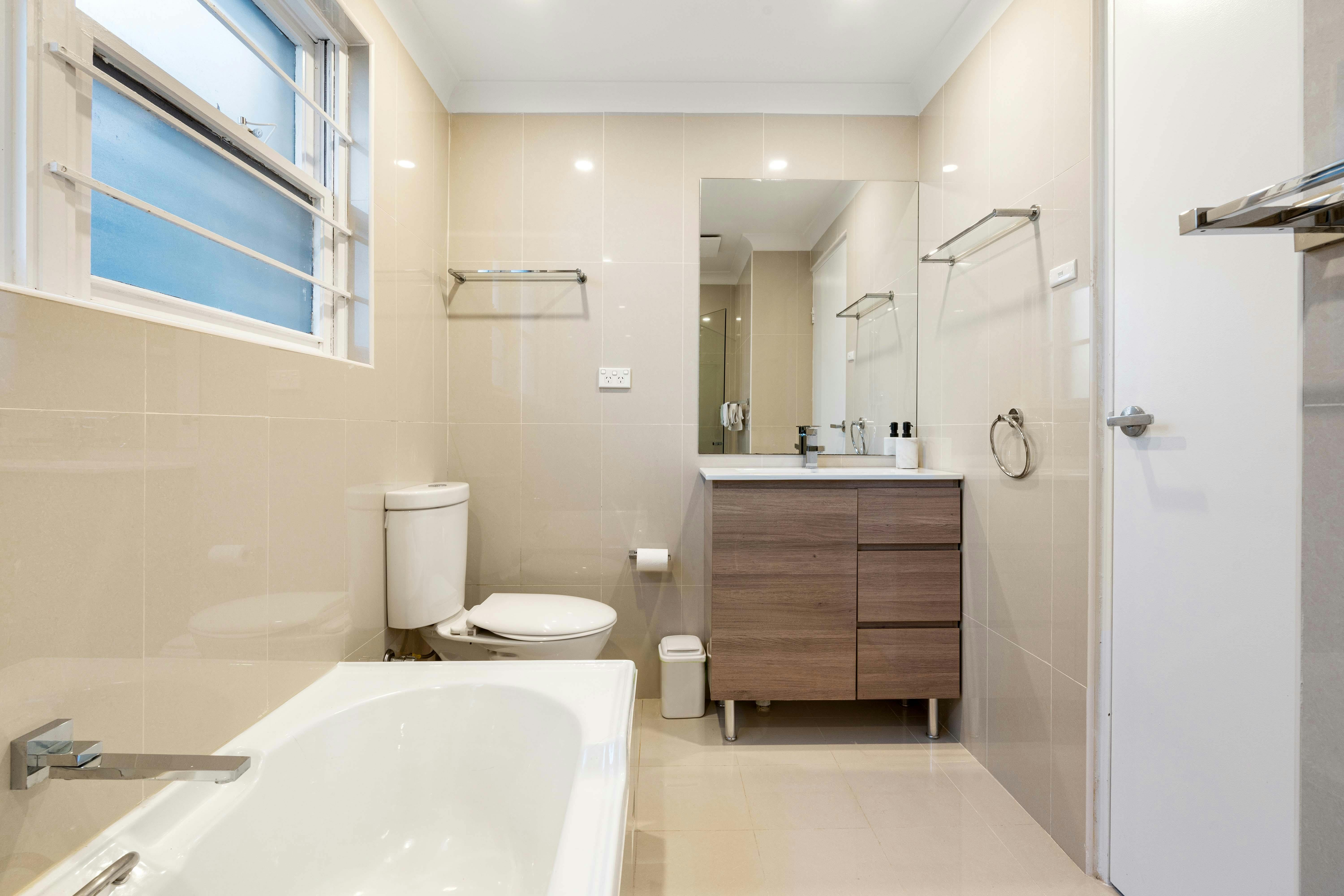 Bathroom with bathtub, mirror, and modern fixtures.