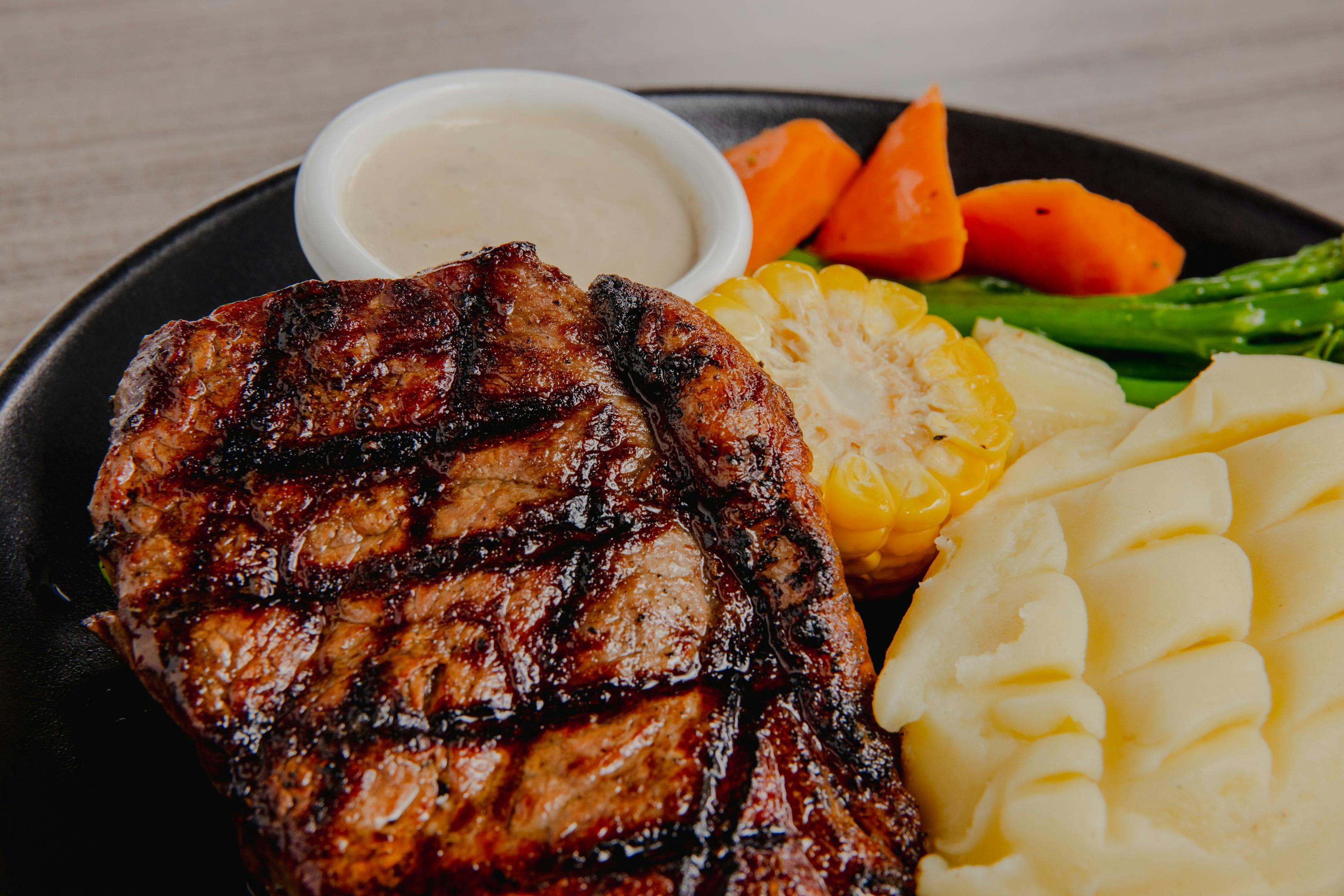 Plate with steak, sauce, mash potato and salad on a table at Orion Hotel Springfield
