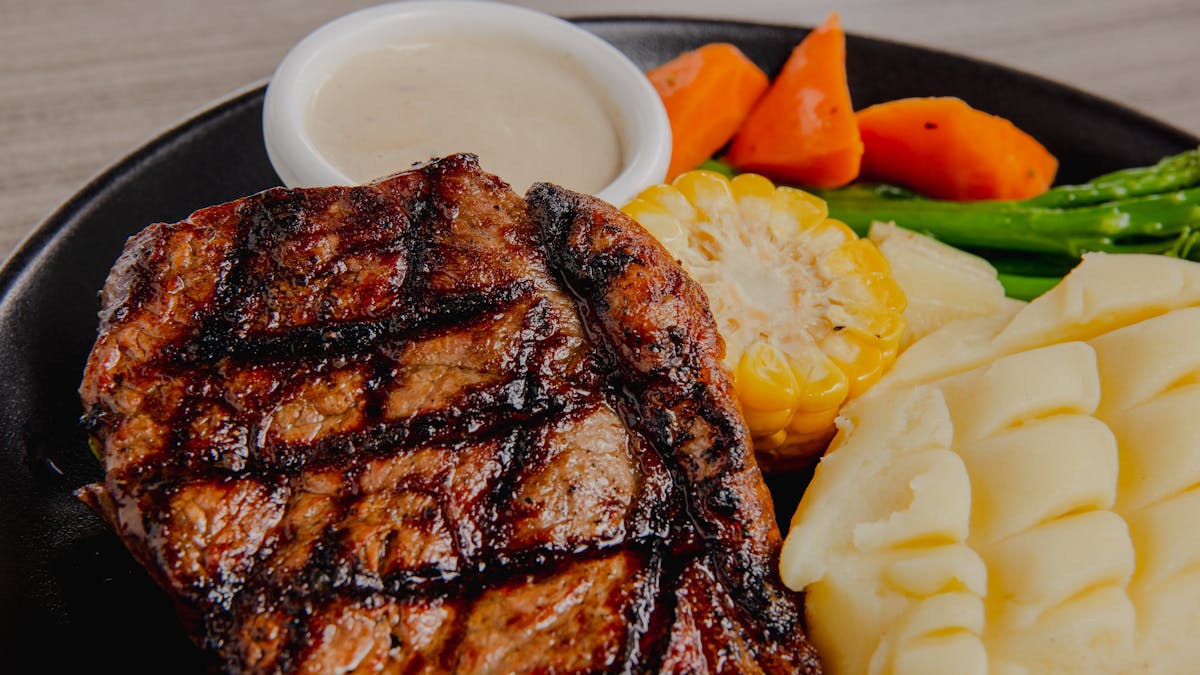 Plate with steak, sauce, mash potato and salad on a table at Orion Hotel Springfield