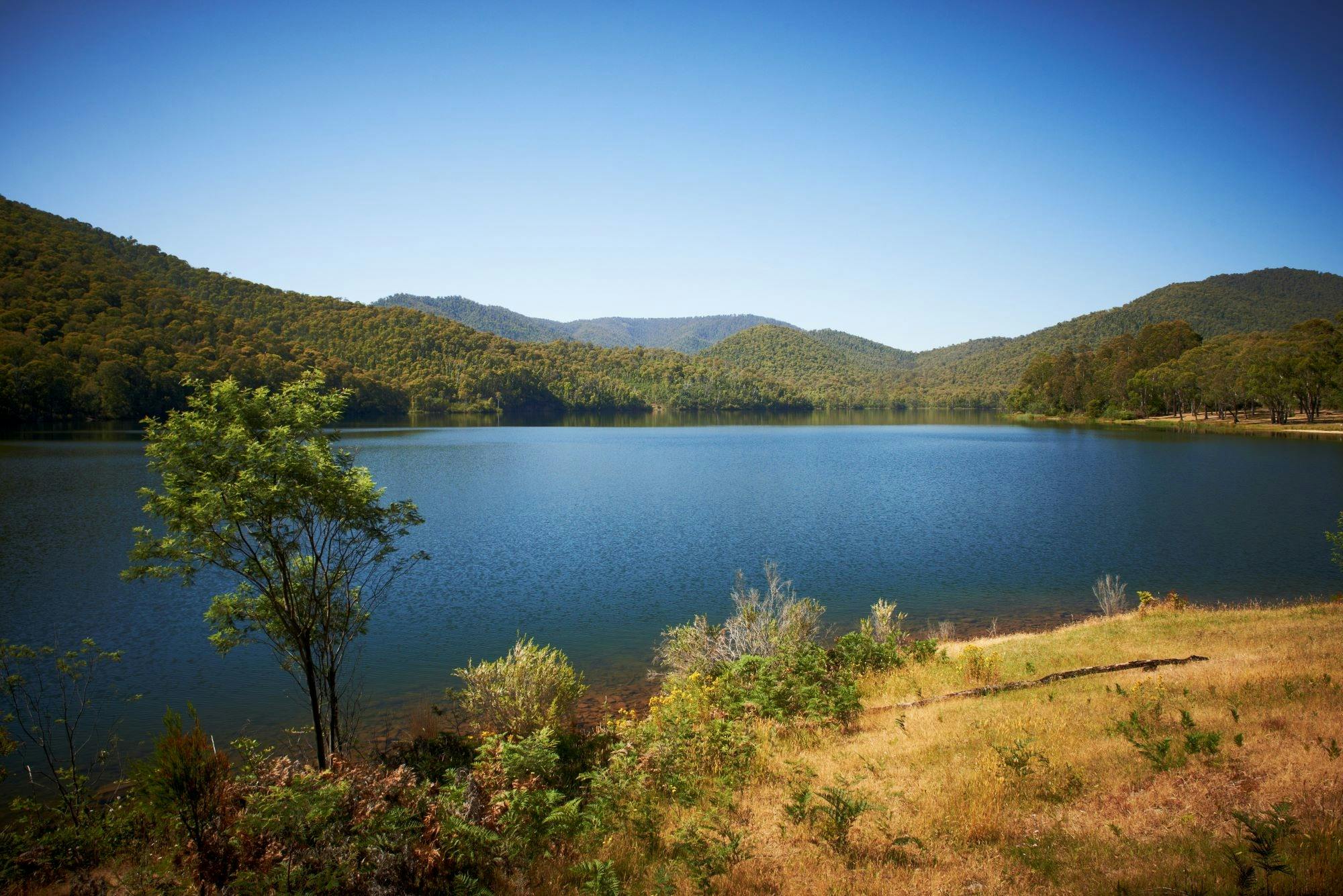 Blue Sky View to mountain behind a very crystal clear still lake in the King Valley