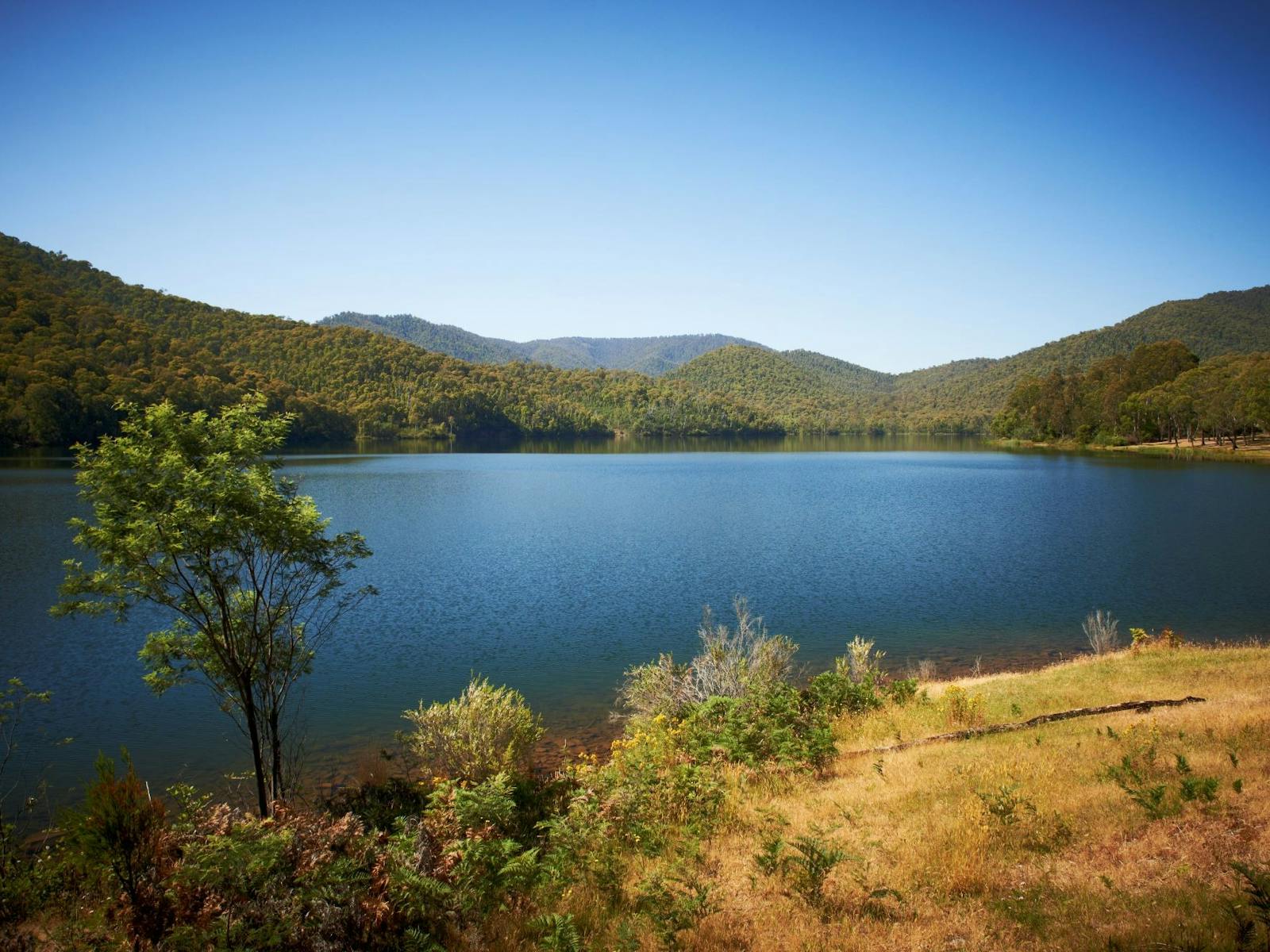 Blue Sky View to mountain behind a very crystal clear still lake in the King Valley