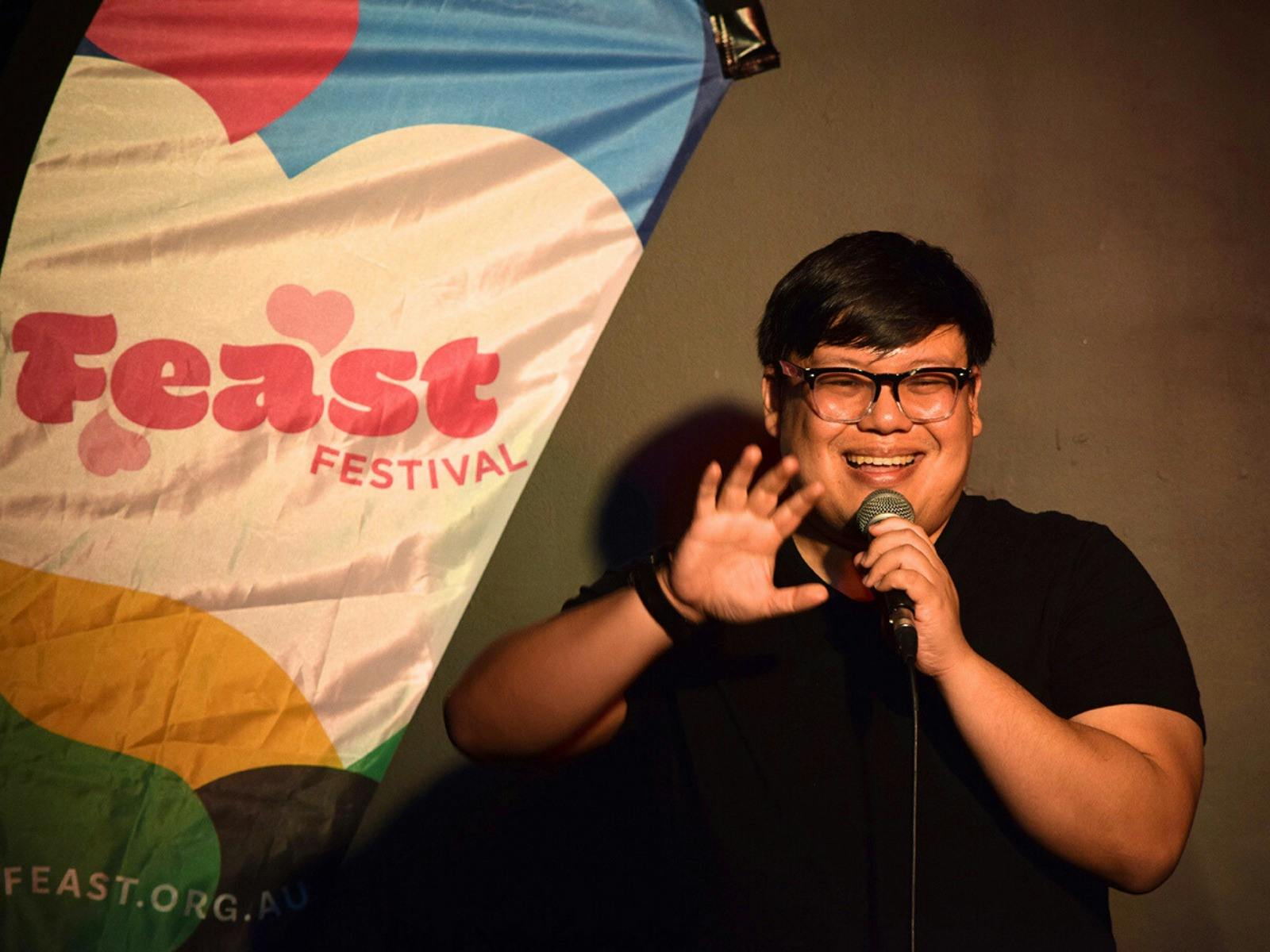 A performer waving with a mic in their hand.