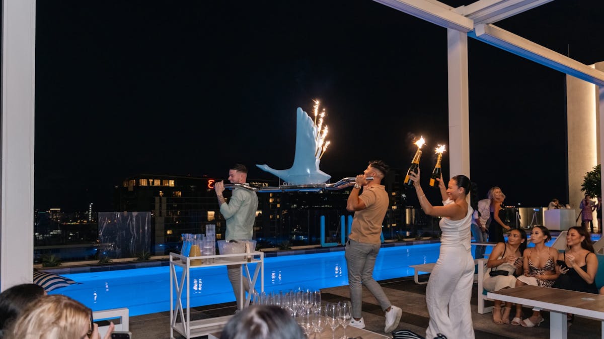 Bottle service at line rooftop, sparkler with bottles of champagne paraded