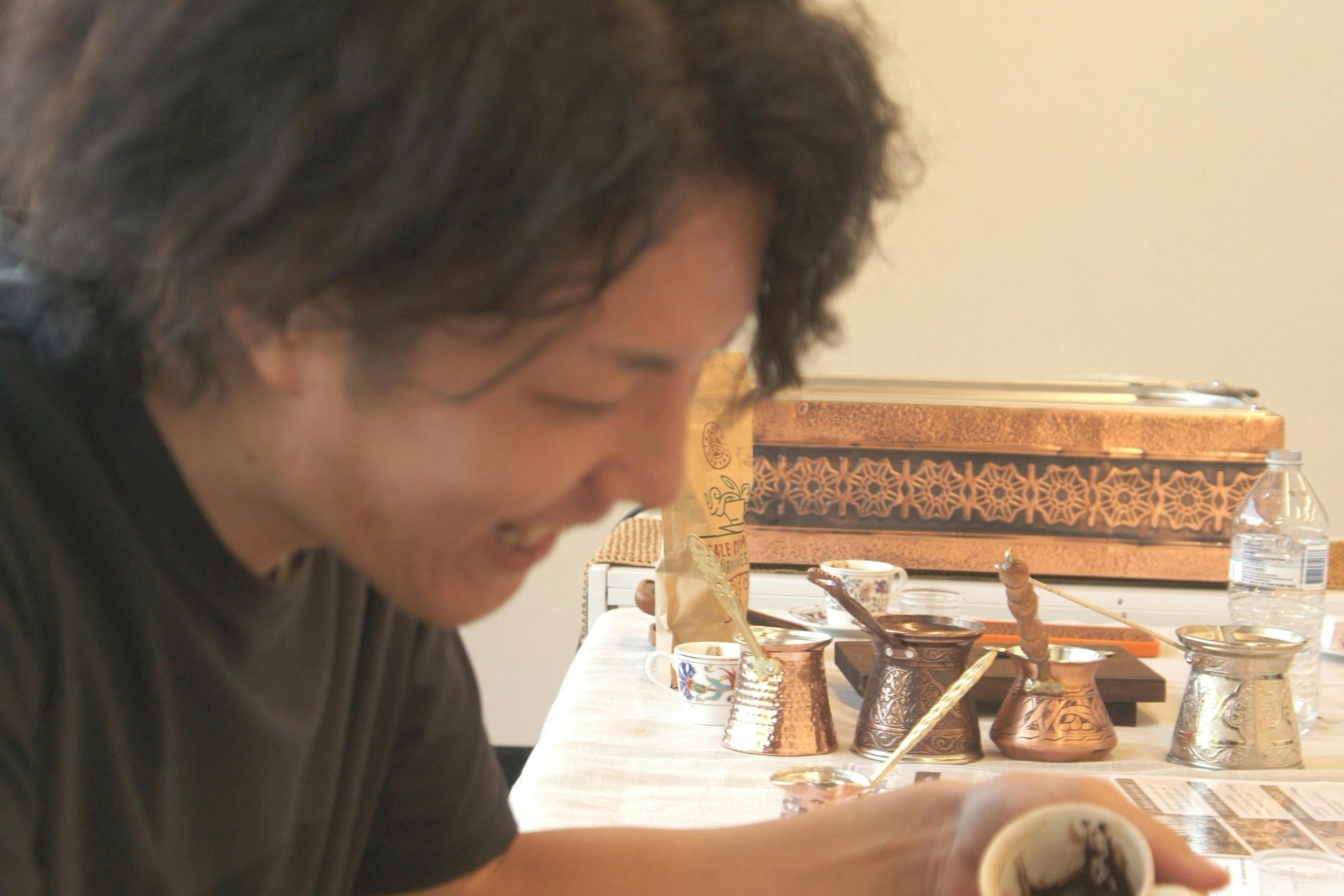 Guests brewing Turkish coffee in copper cezves on hot sand