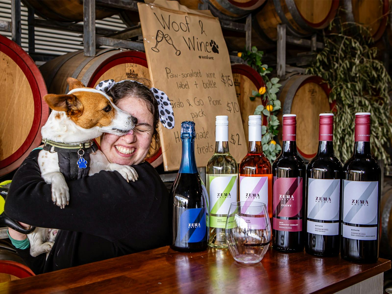 Dog licks Georgie Zema's face at the Woof and Wine Walk 2025