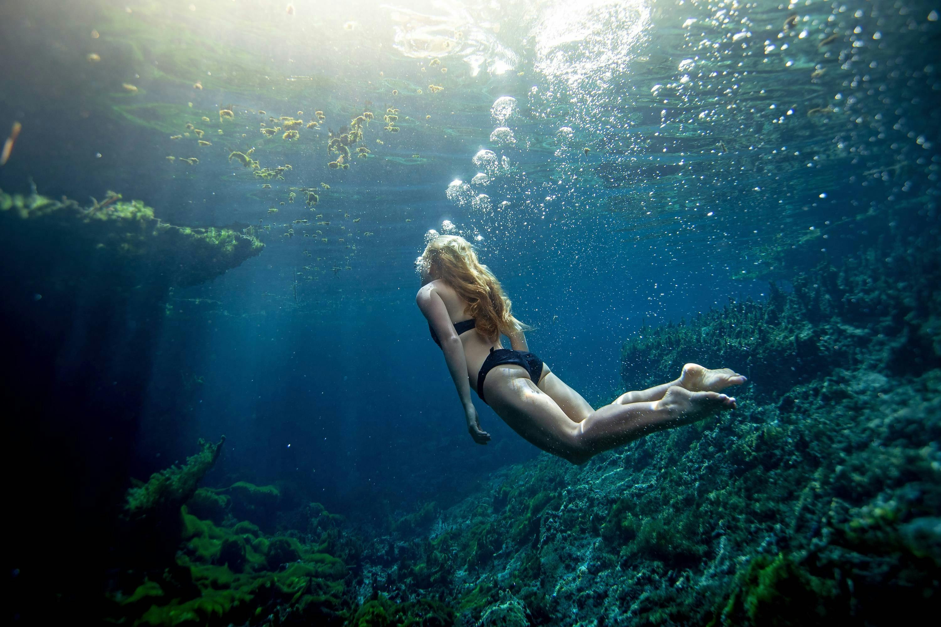 Woman swimming under the water in the Mataranka thermal pool