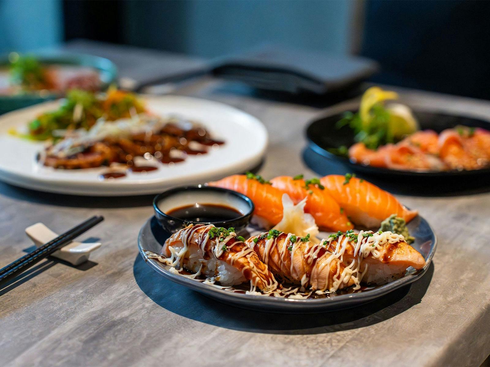 KOI Bar & Restaurant cold bites spread including nigiri & aburi, tuna tatami and salmon carpaccio.