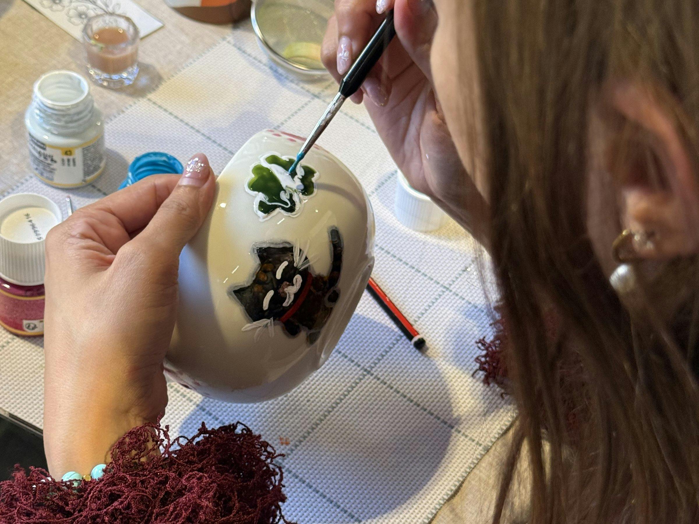 Guest hand-painting a ceramic cup at a NOA Matcha workshop