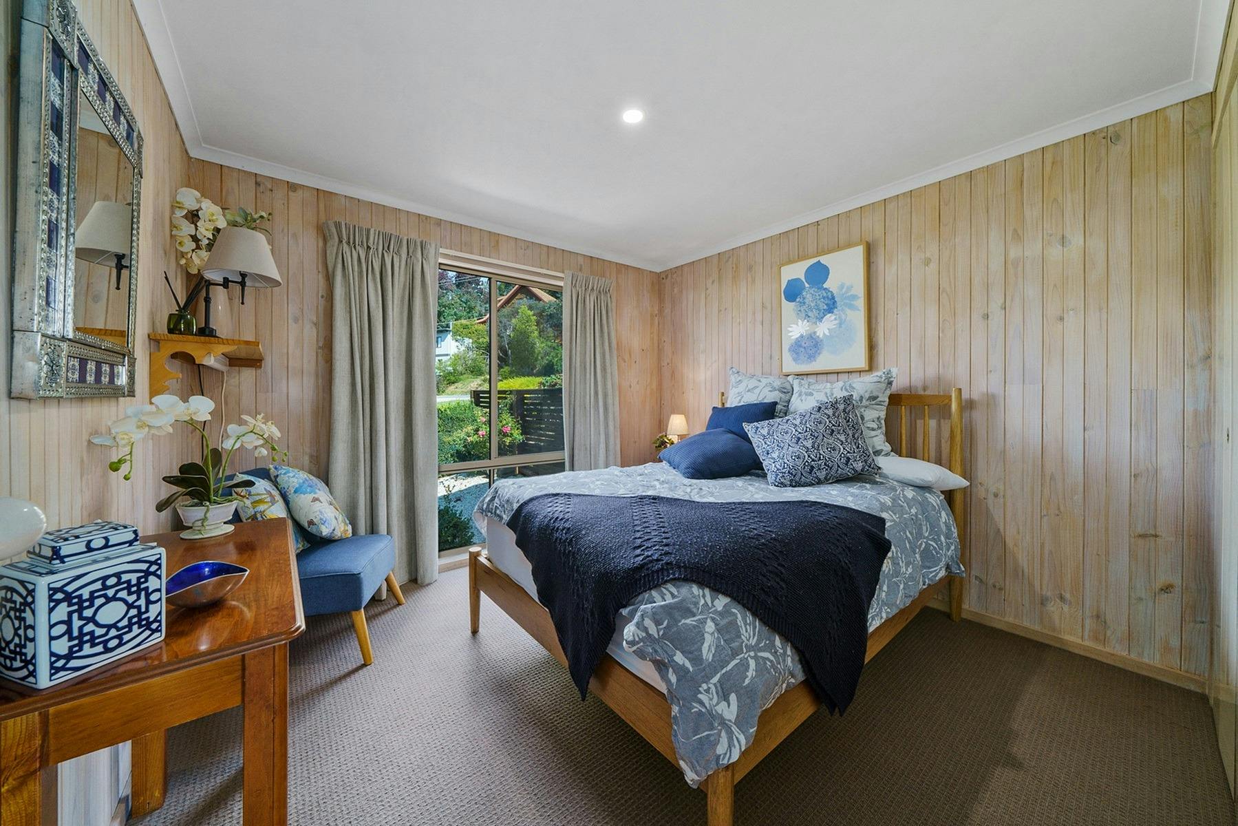 A bedroom with a bed, desk, and chair in the corner