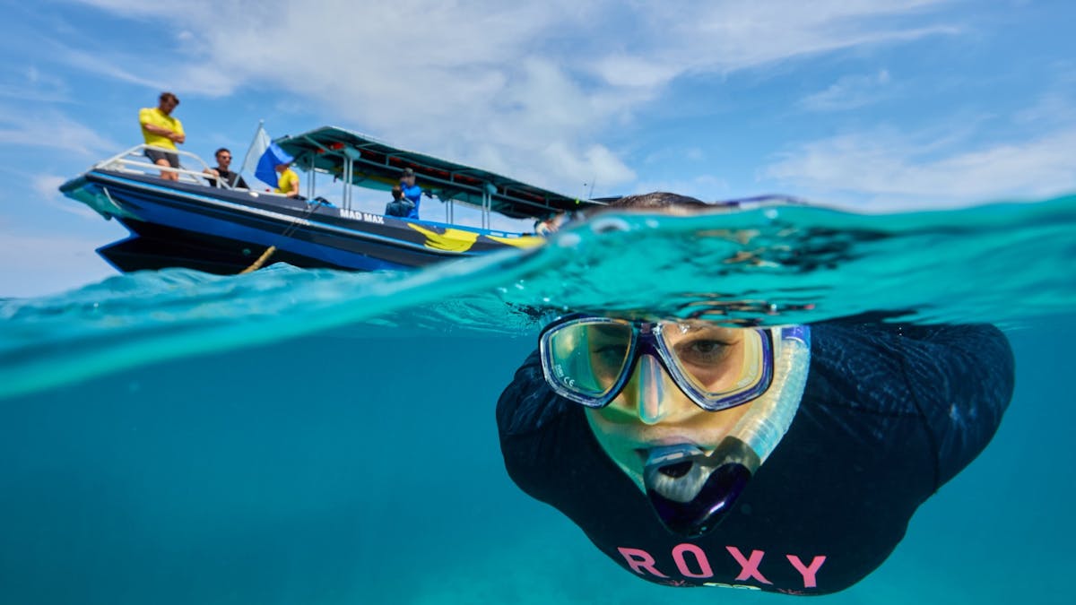 Snorkeller with boat in background