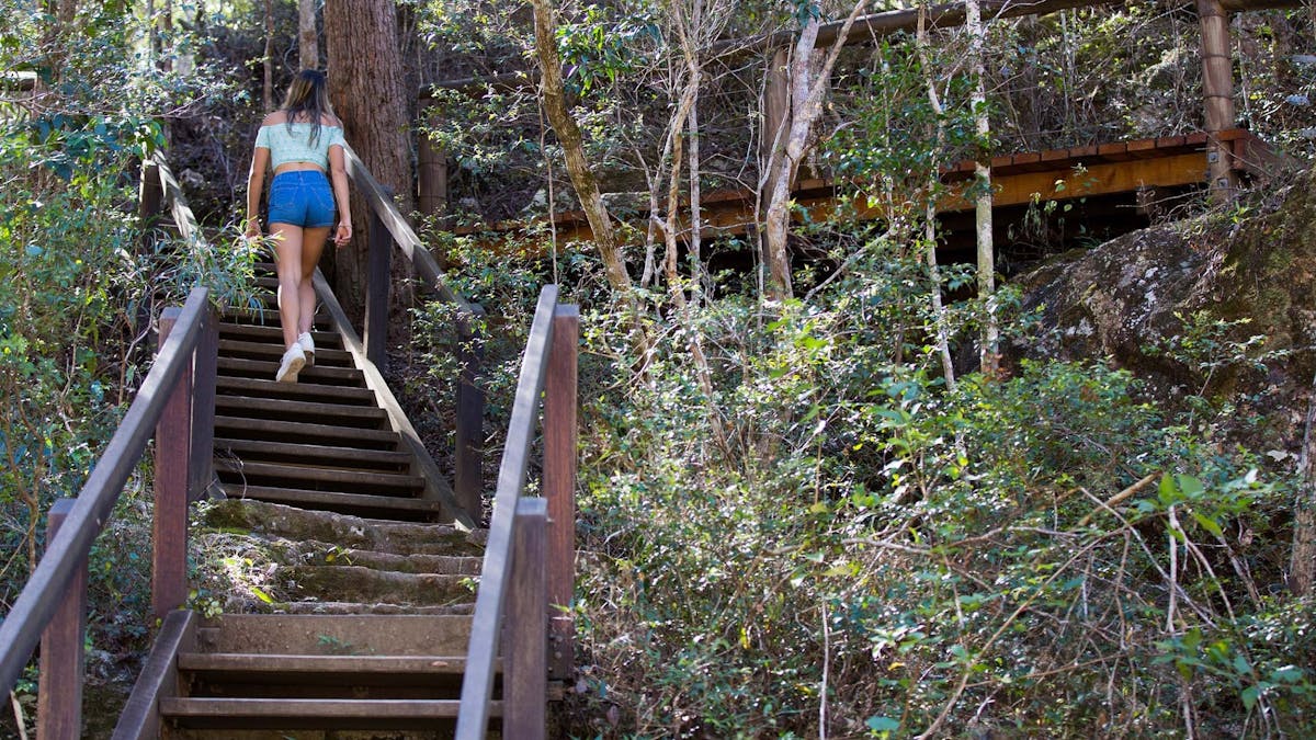 Woman walking up the stairs to Rocky Hole in the Mount Mee Forest Reserve
