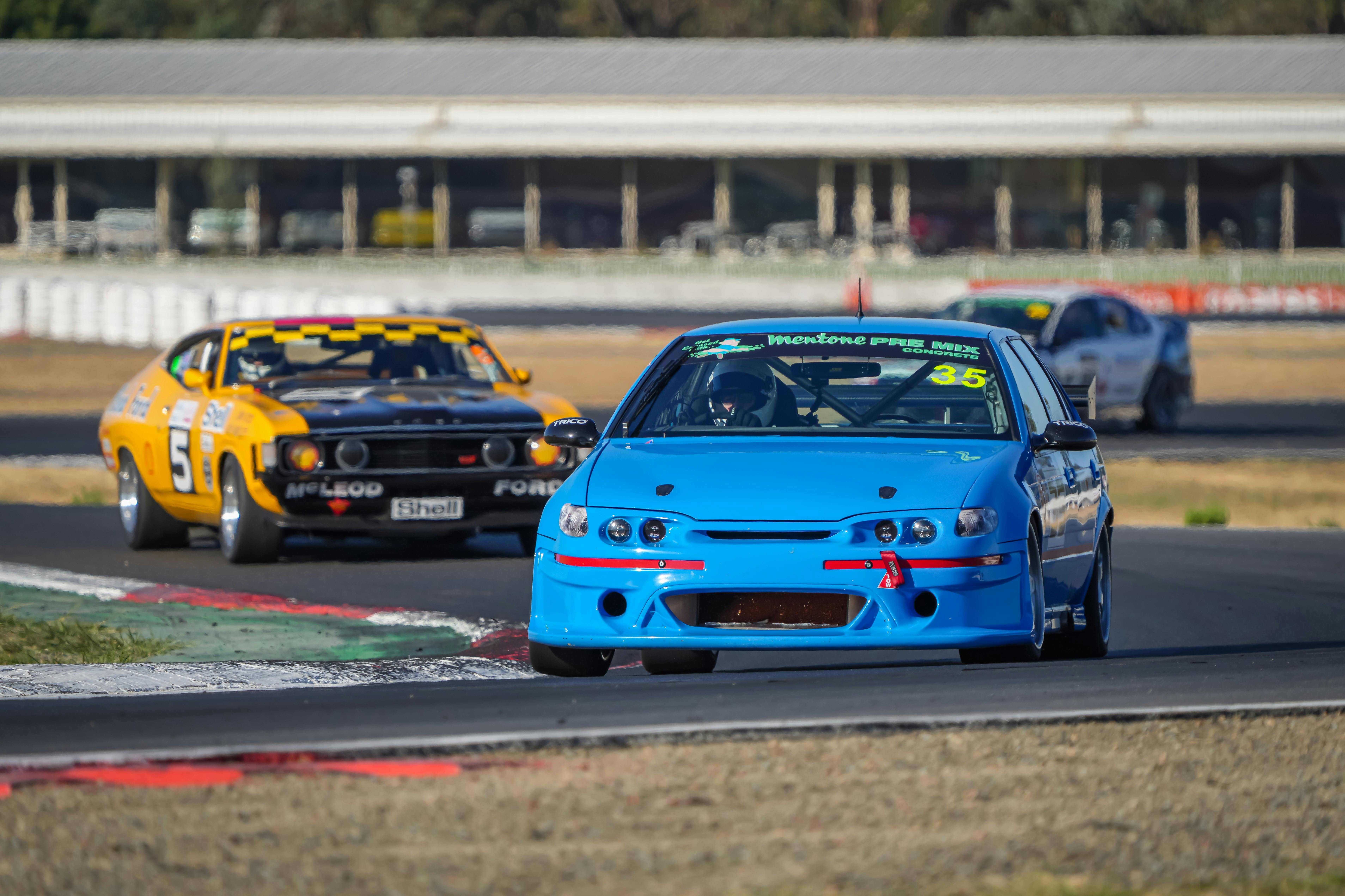 Cars going around a corner on a racetrack