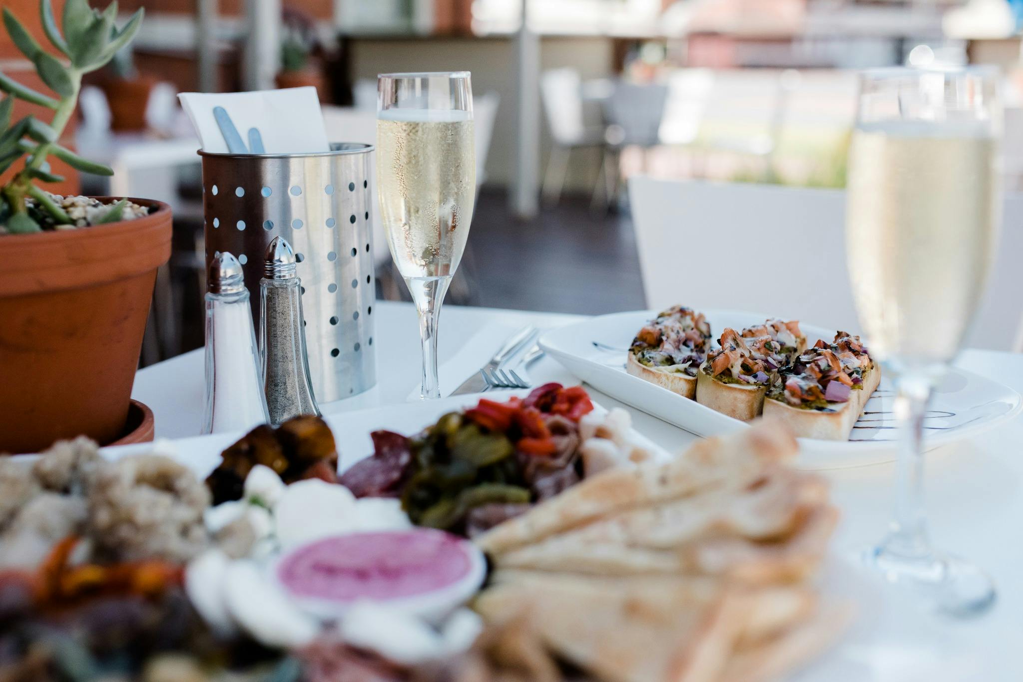 A shared platter and sparkling wine served in our relaxed outdoor dining area.