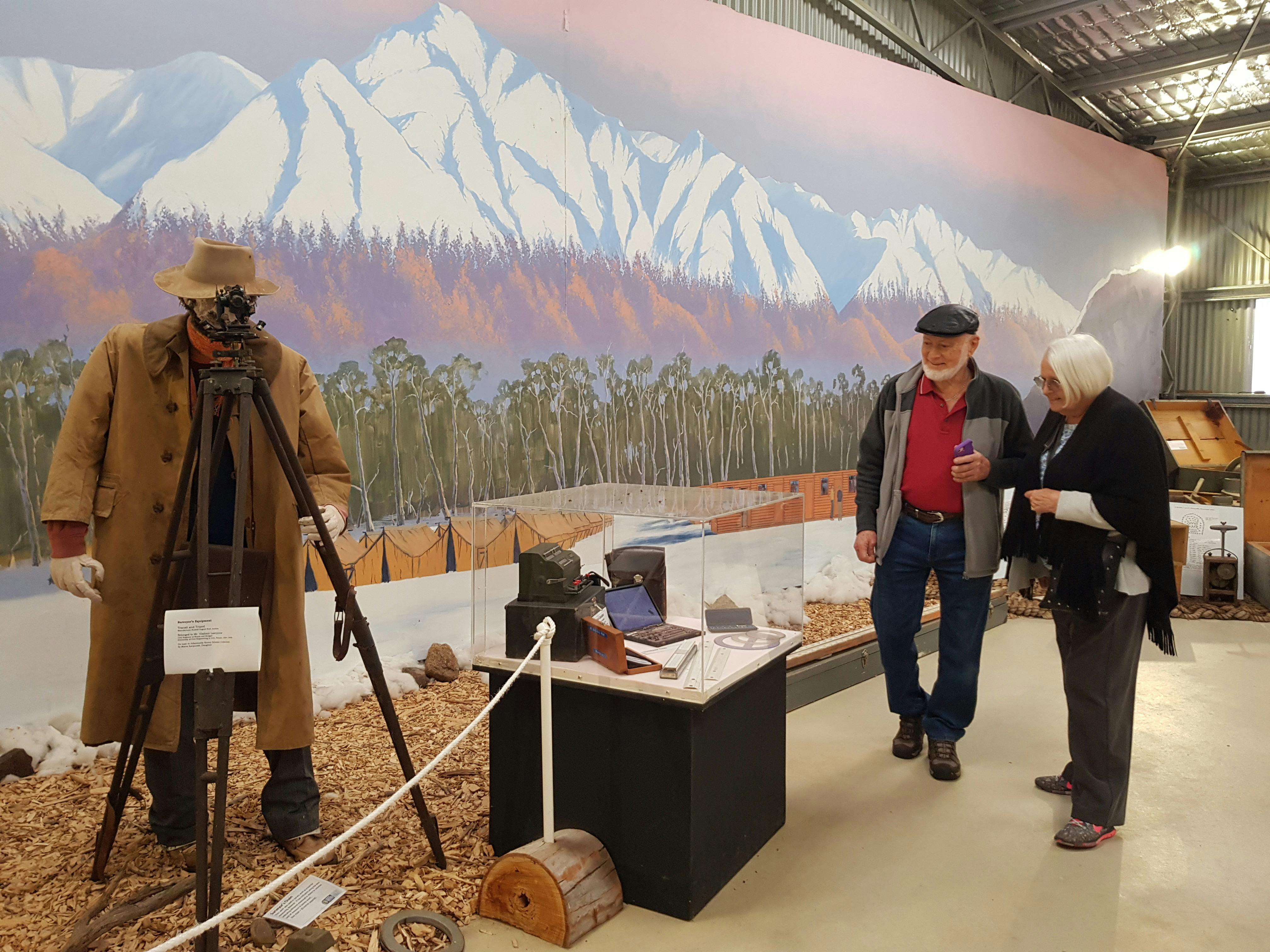 man and woman in front of mountain mural