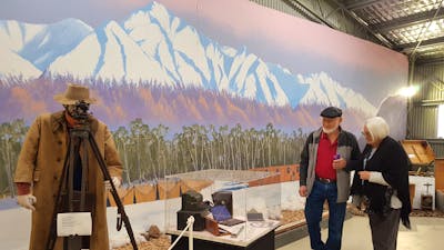 man and woman in front of mountain mural