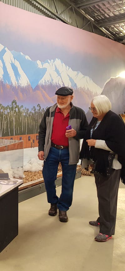 man and woman in front of mountain mural