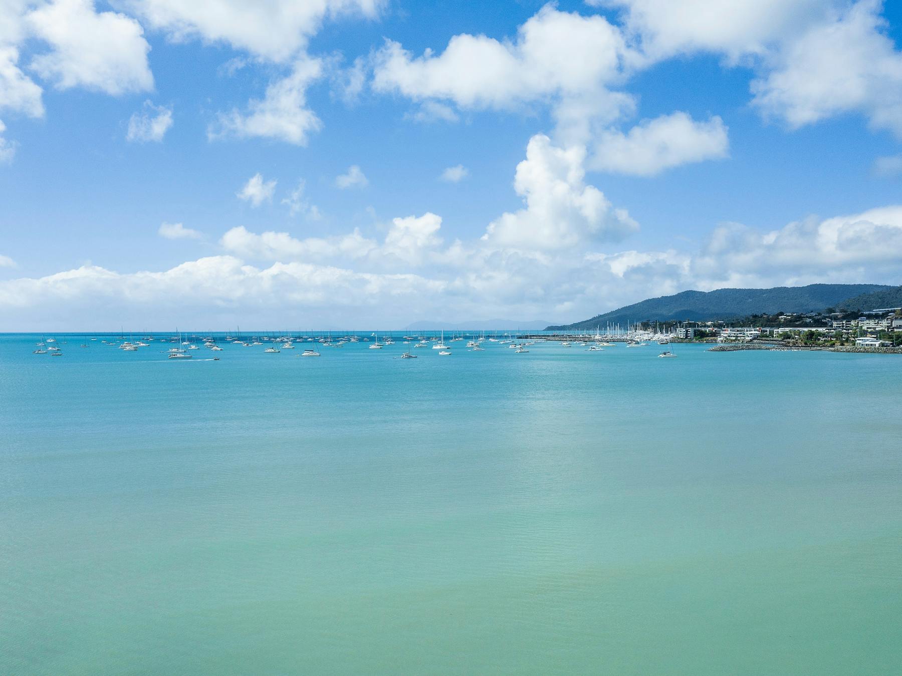 Ocean view from Cannonvale Beach overlooking sailing boats and Airlie Beach in the background