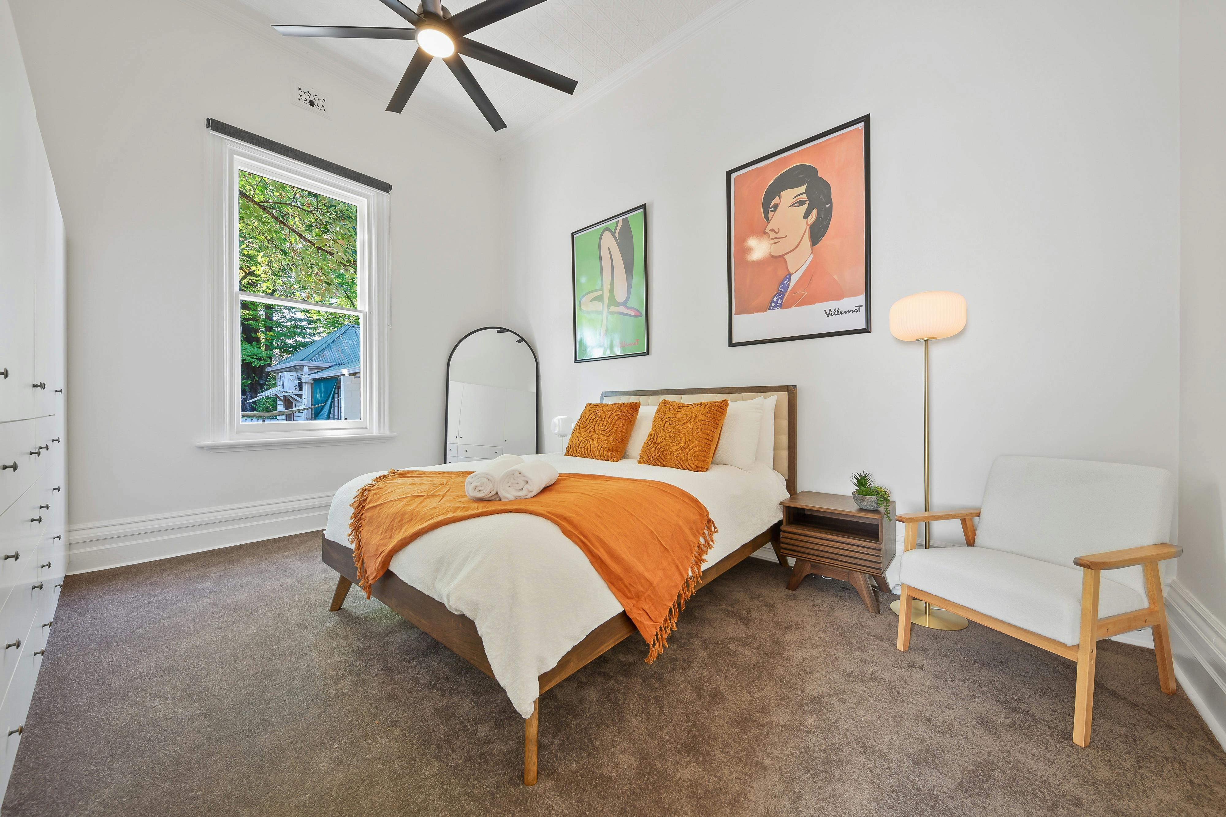 Queen sized bed with large mirroe and bedside tables and lamps