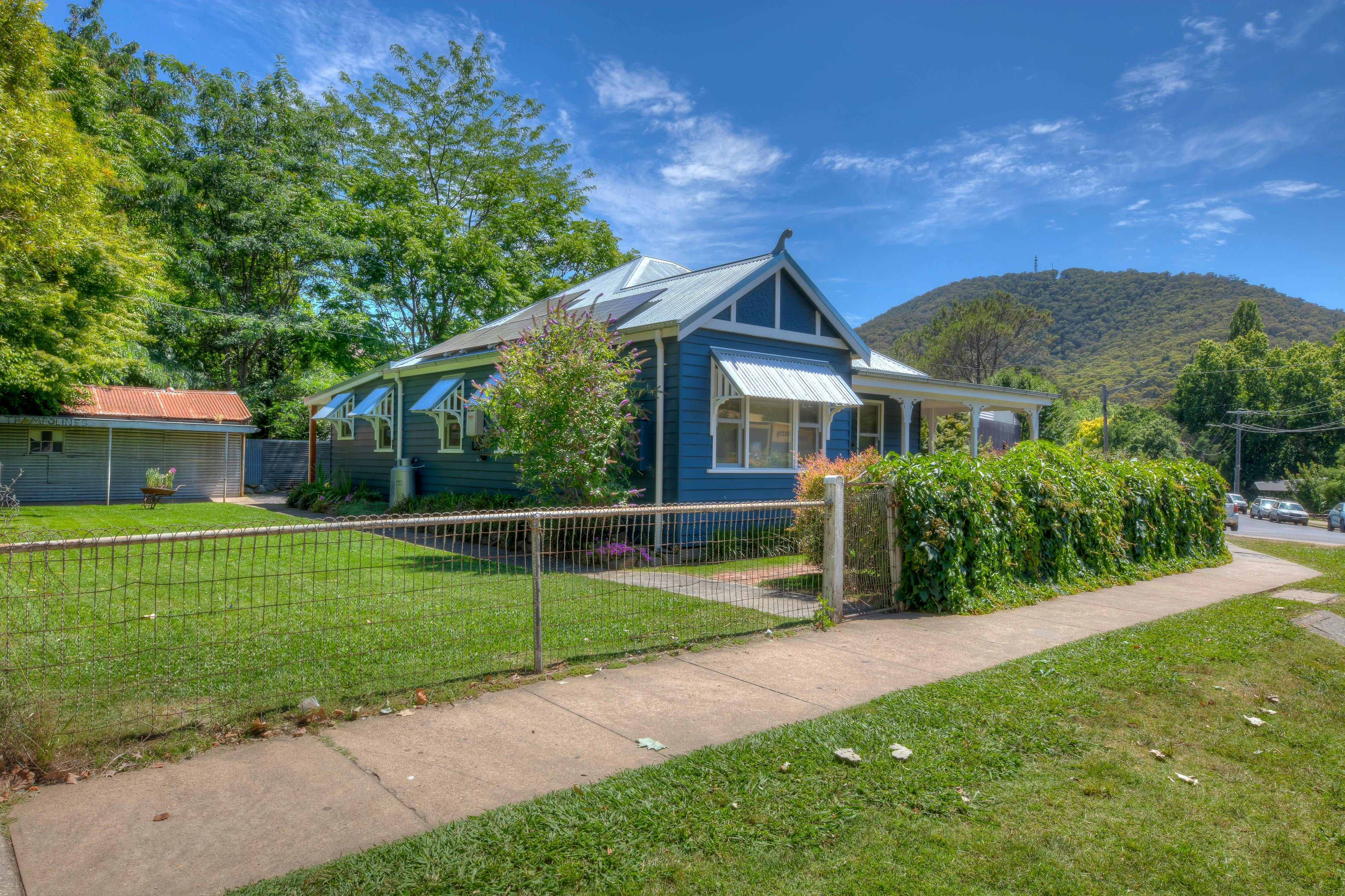 Corner Cottage Bright Exterior with a lawn