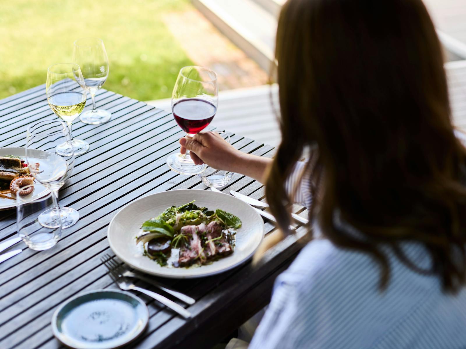 A brunette woman at an outdoor table at Josef Chromy Restaurant, Launceston