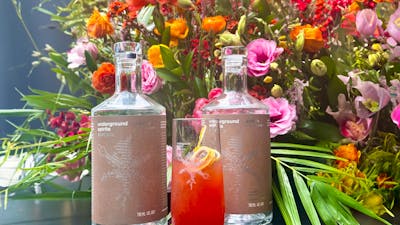Bottle of Underground Spirits Caramel Vodka surrounded by bright florals
