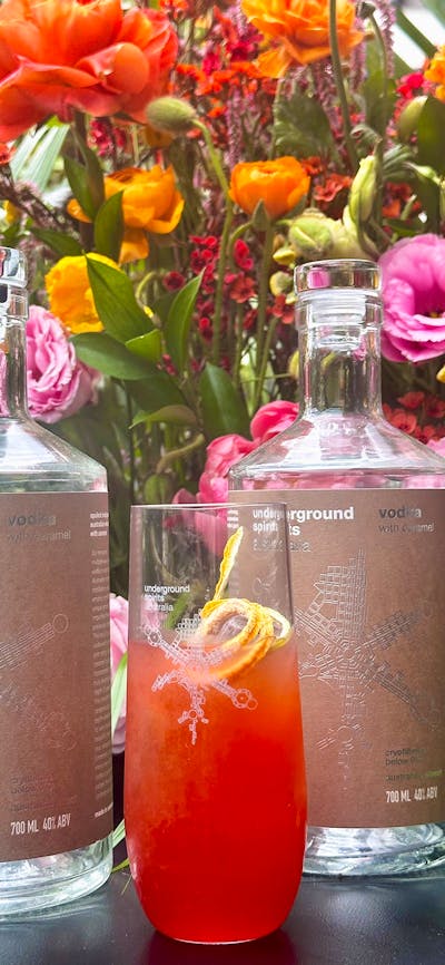Bottle of Underground Spirits Caramel Vodka surrounded by bright florals