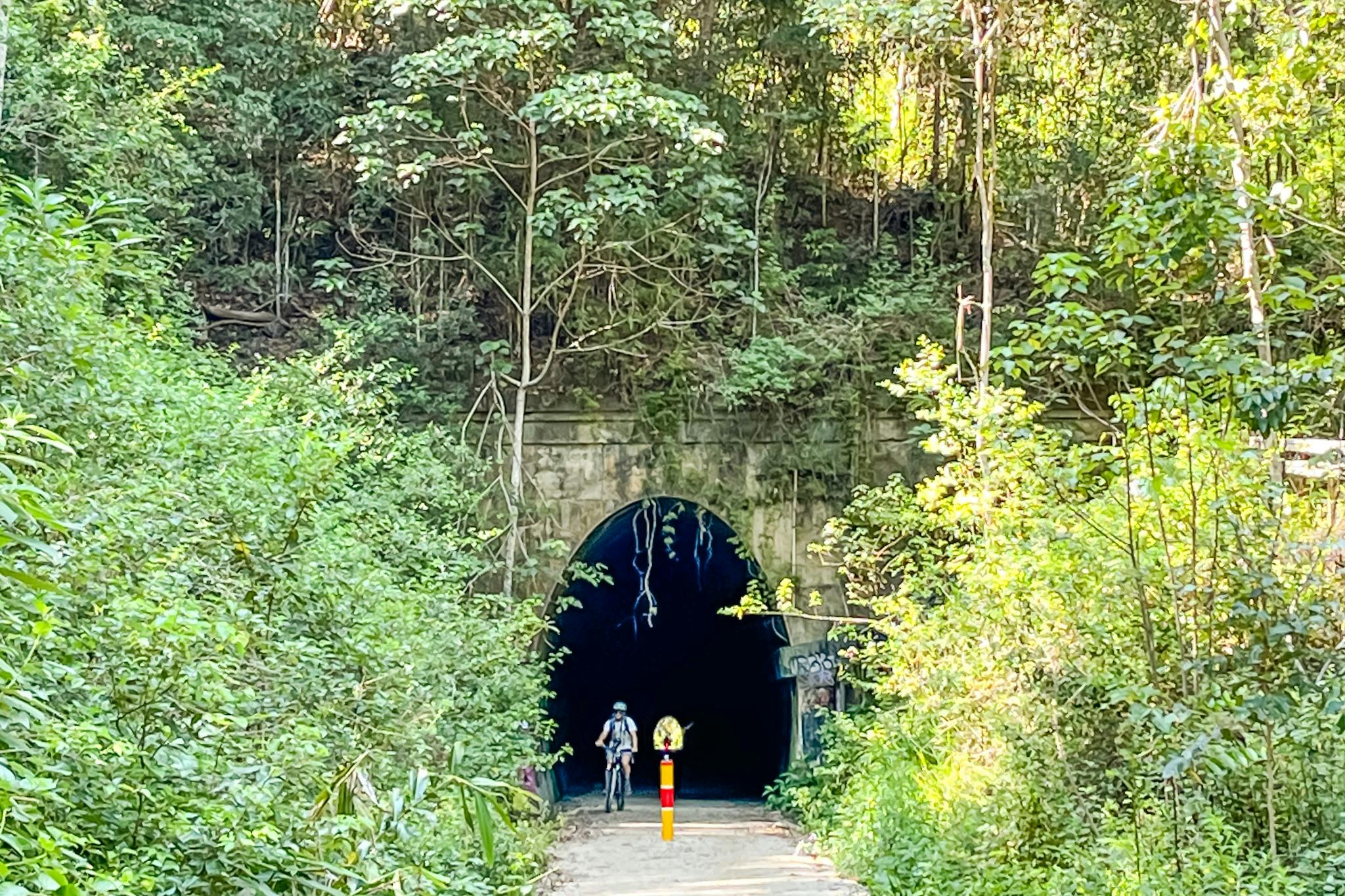 E Bike rider shown at the entrance to the Burringbar Range tunnel on the rail trail