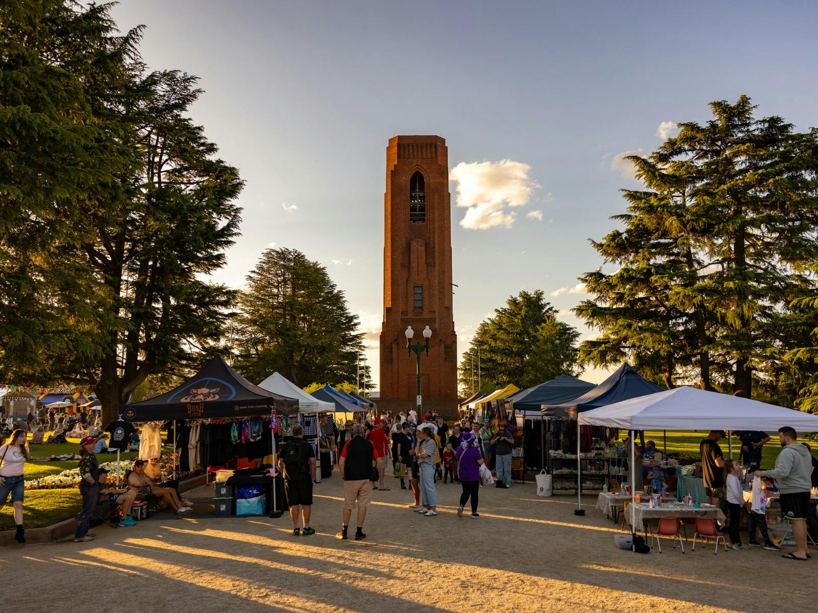 Market stalls in park with Carillon in background.