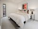 Reed arthouse townhouse bedroom with bed, table side lamps, painting on the wall