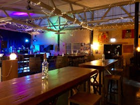 Our back room lit for a live music function with stage set up for a band, benches and seats