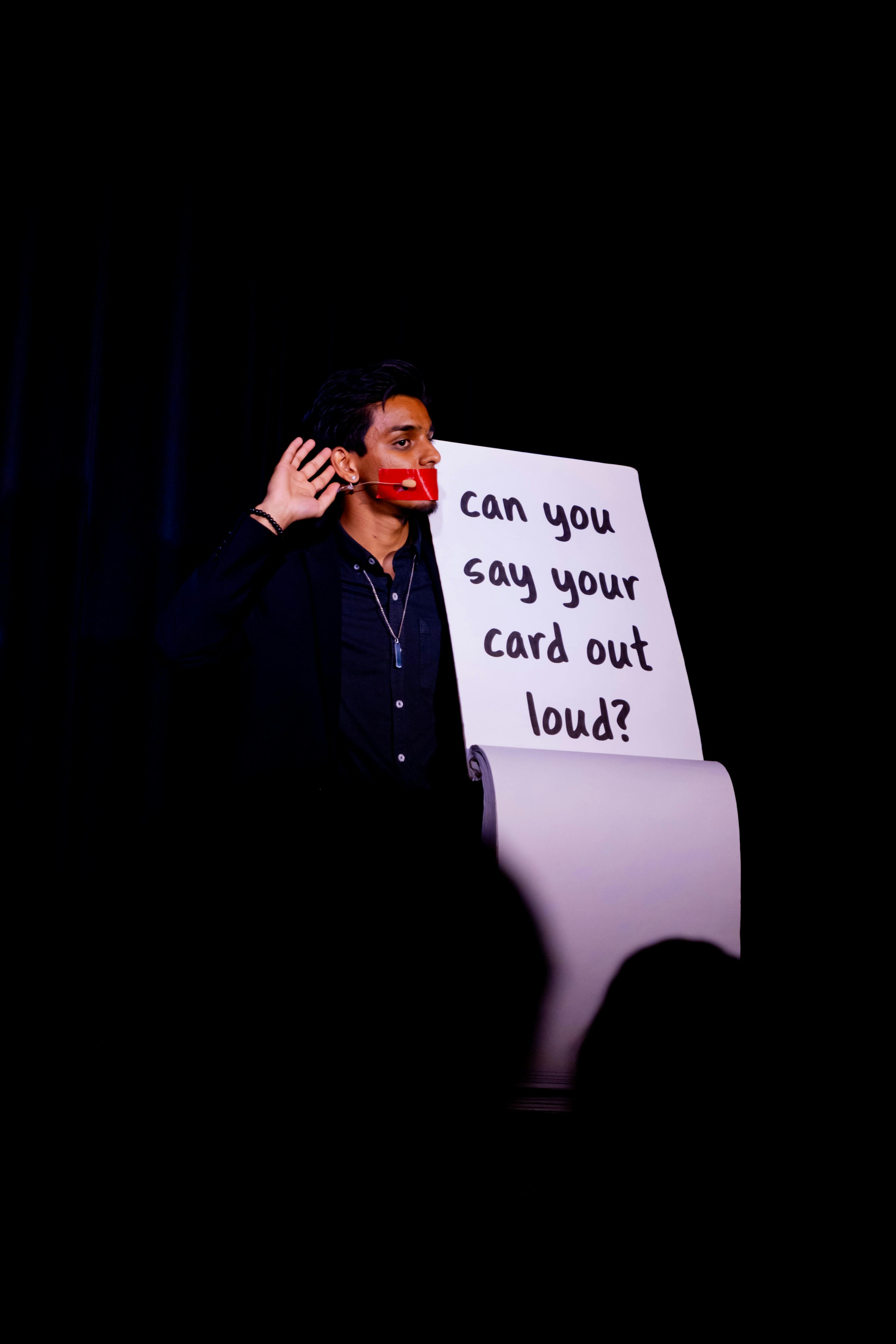 Aadi Holding Up A Board With His Mouth Tapped