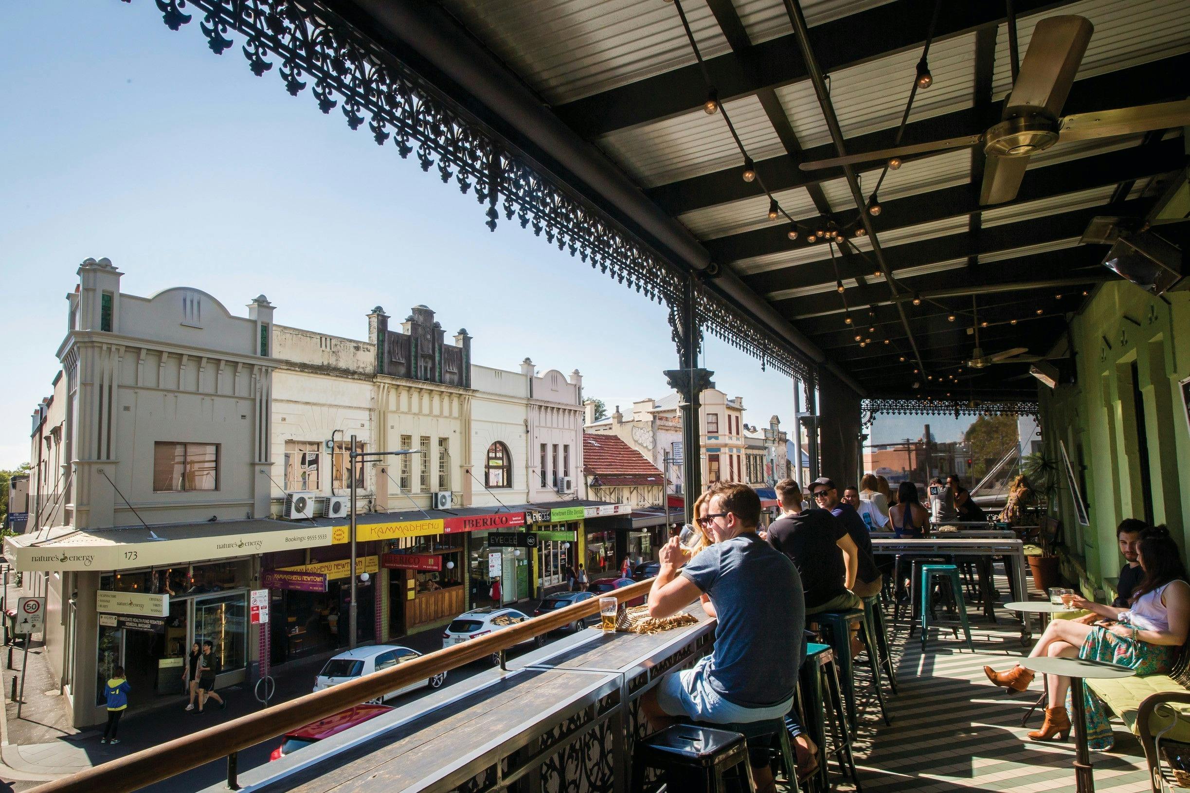 Patrons enjoying a drink on the sun-filled verandah at Newtown Hotel, Newtown