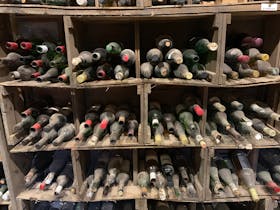 image of dusty wine bottle on old rack