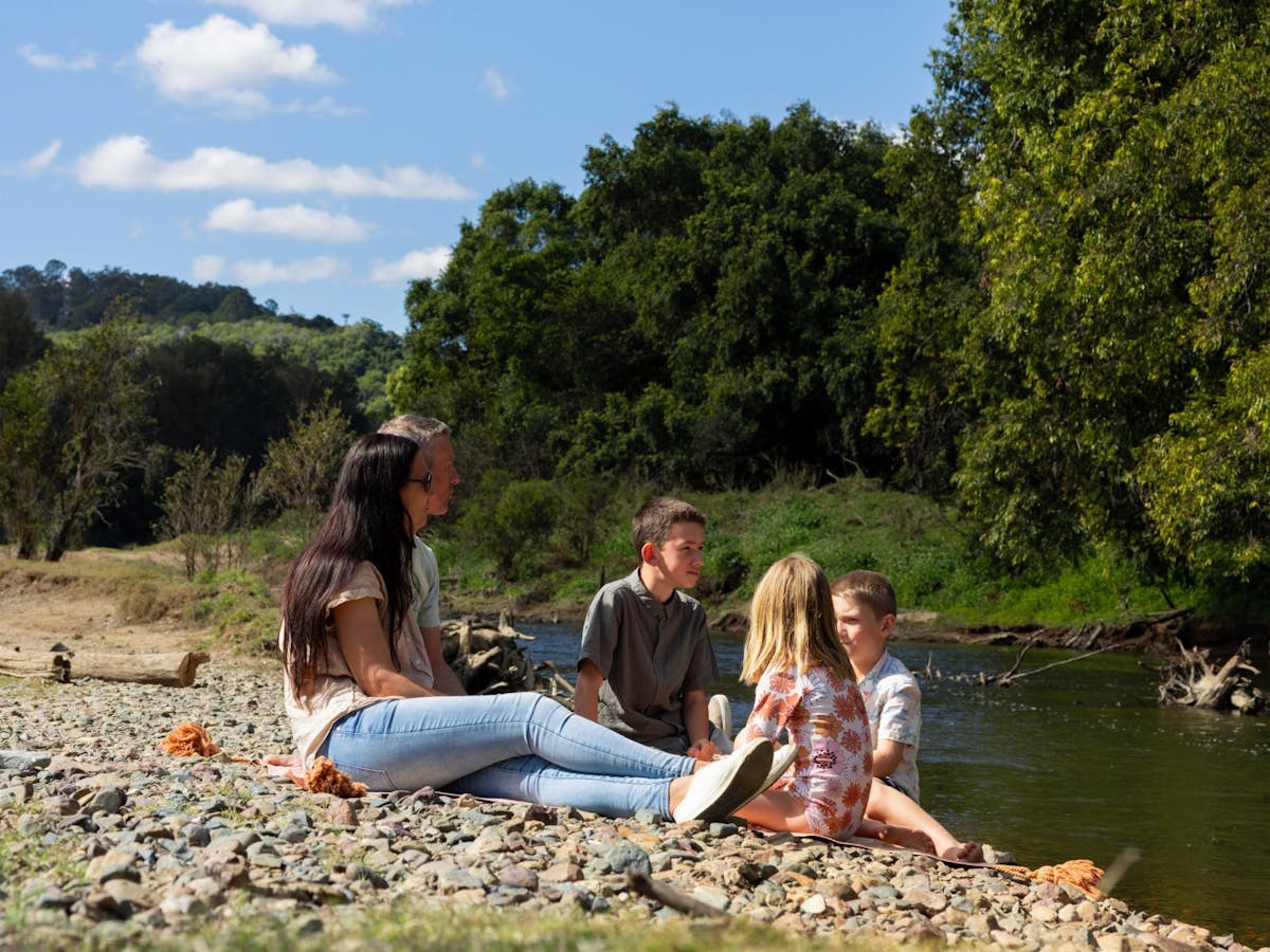 A family sitting beside the river