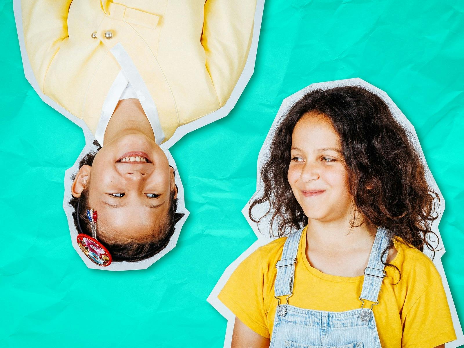 Two children smile at each other - one is upside down