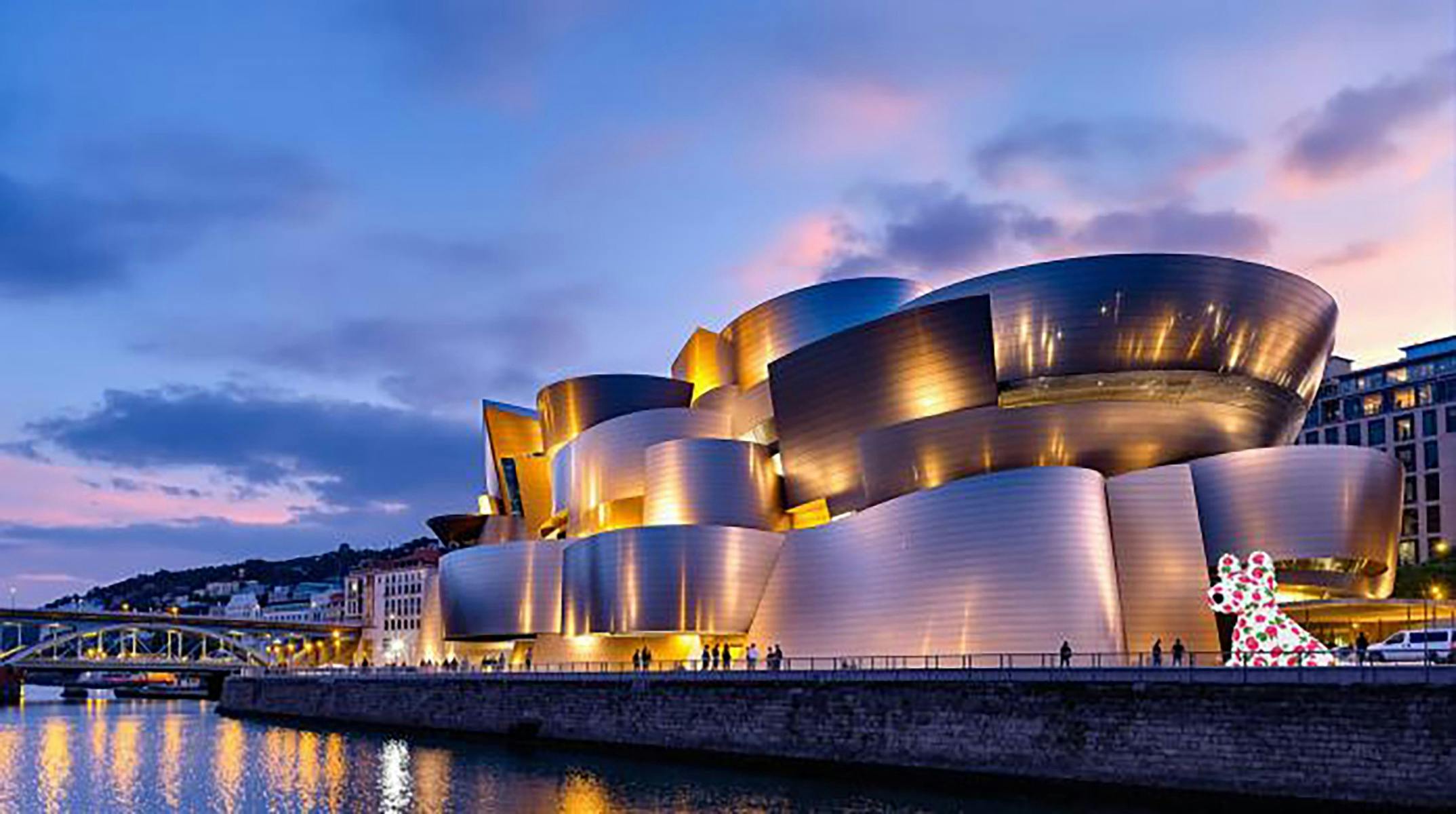 A modern building lit up at sunset