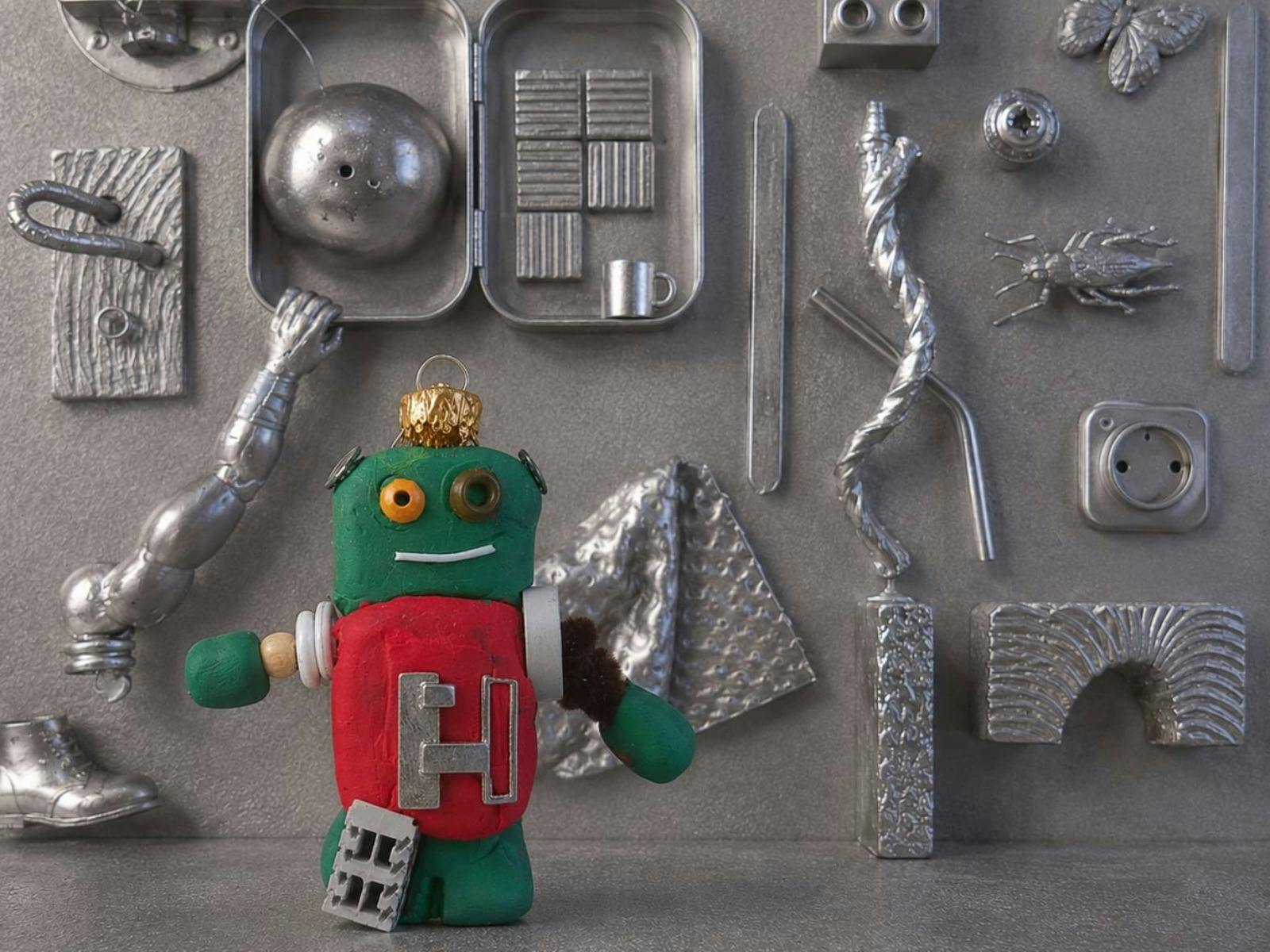Toy robot surrounded by objects painted in silver such as a boot, cockroach and butterfly