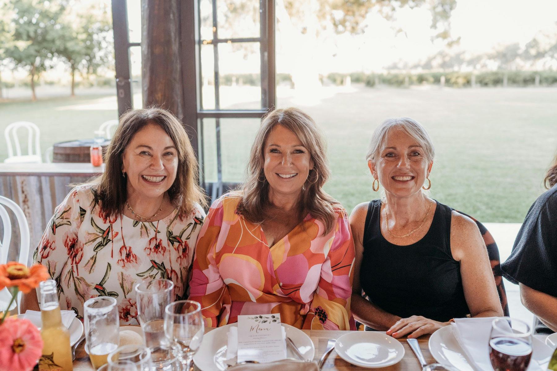 Three female guests enjoying lunch in the Pavilion, overlooking the lawn and Calliope Vineyard.