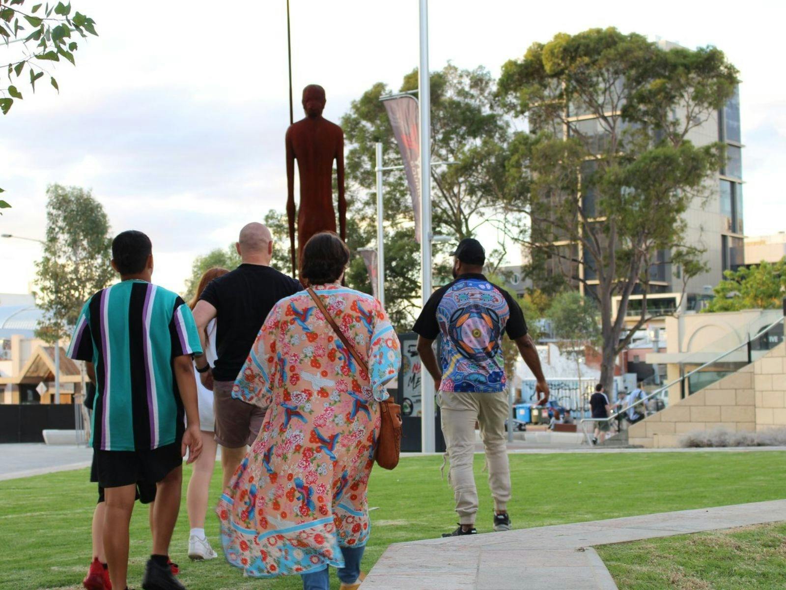 Justin leading tourist in Yagan square with statue of Wirin in background.