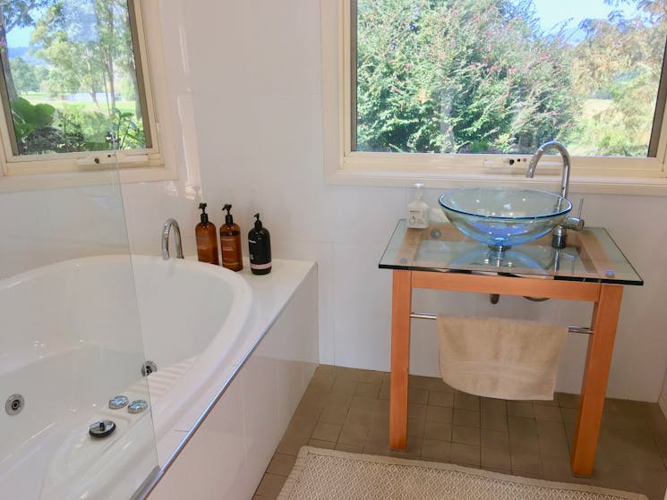 Family bathroom with double spa bath and laundry cupboard