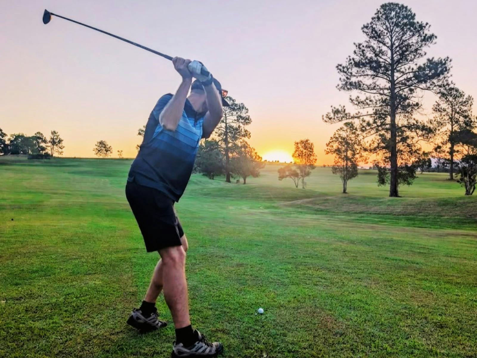 A Golfer hitting at Sunset on the 7th hole