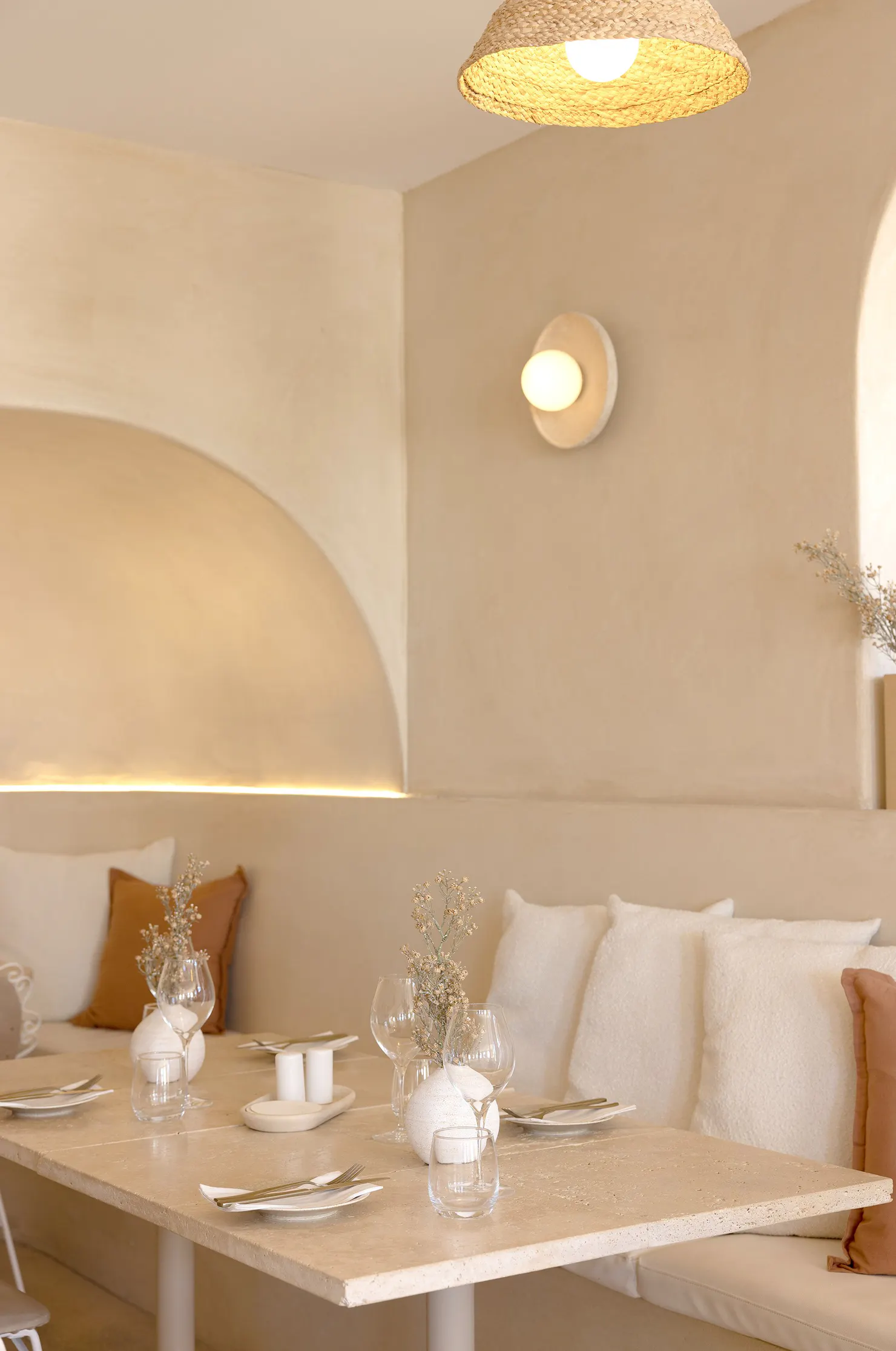 Set table inside CASA restaurant, featuring minimalist coastal luxe interiors with natural textures,