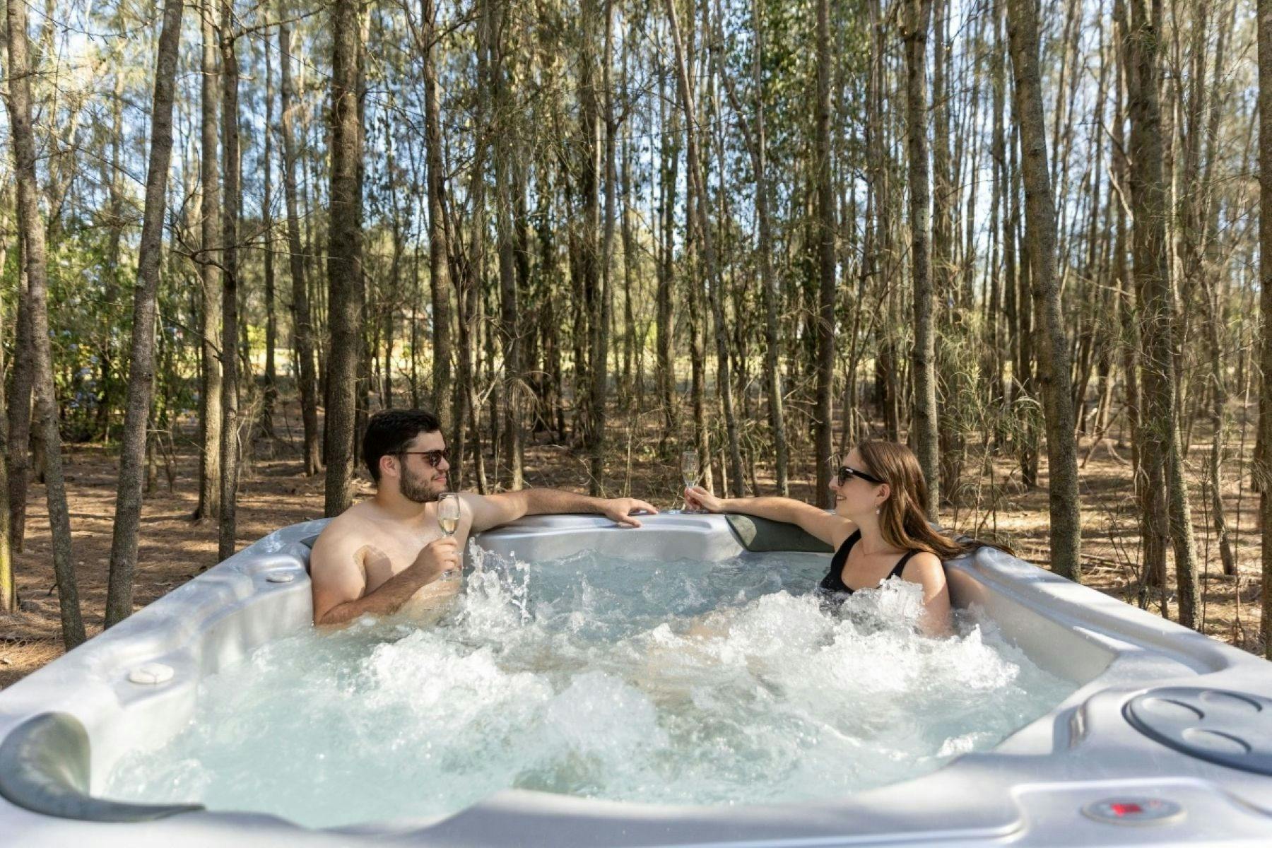 Enjoy a glass of local wine in the outdoor hot tub  in the woods.