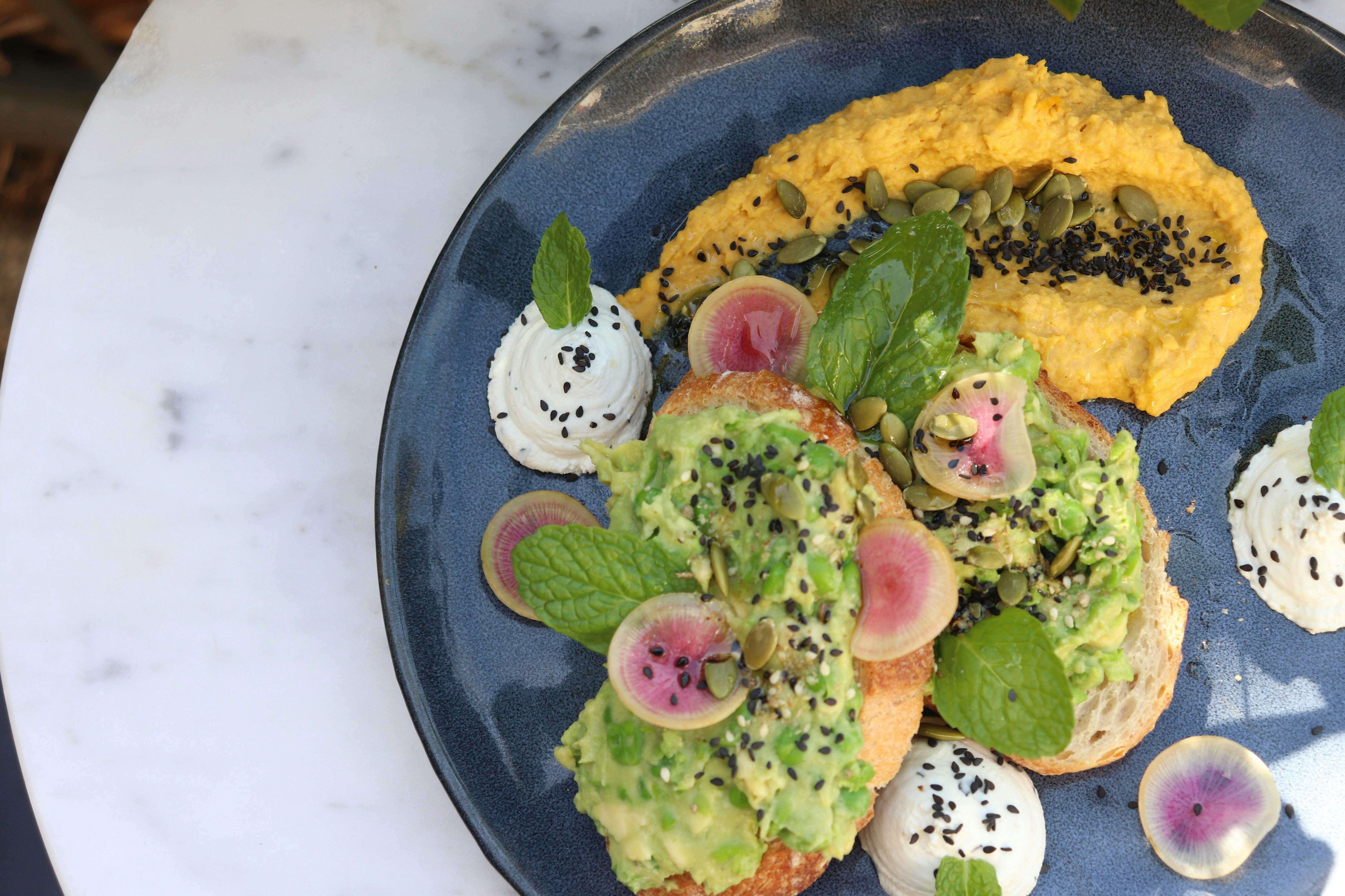 The Pantry's most loved Smashed Pea and Avo toast with pumkin hummus and whipped goats curd.